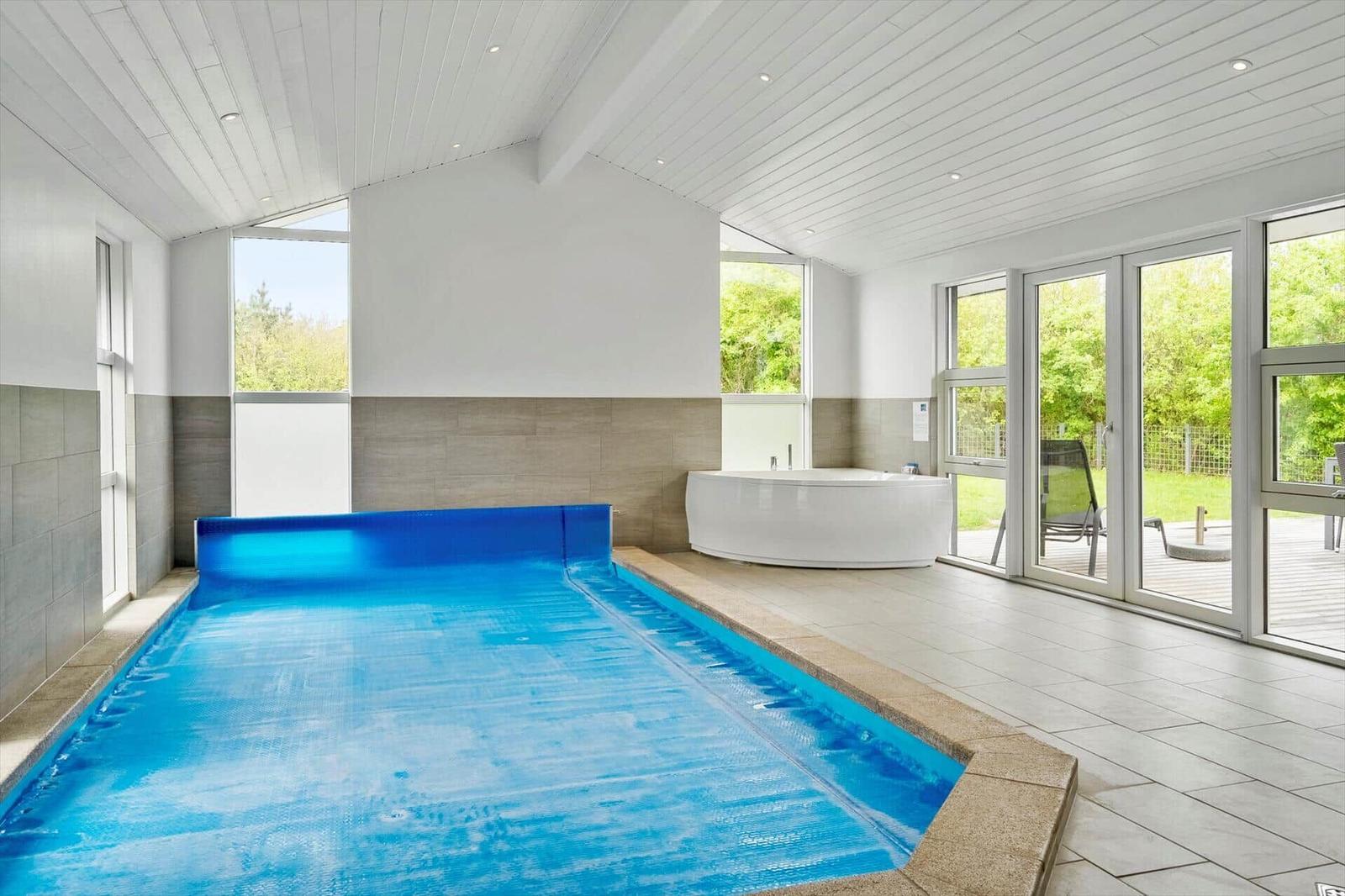 Innenpool mit Whirlpool und großzügigem Fensterblick auf Garten