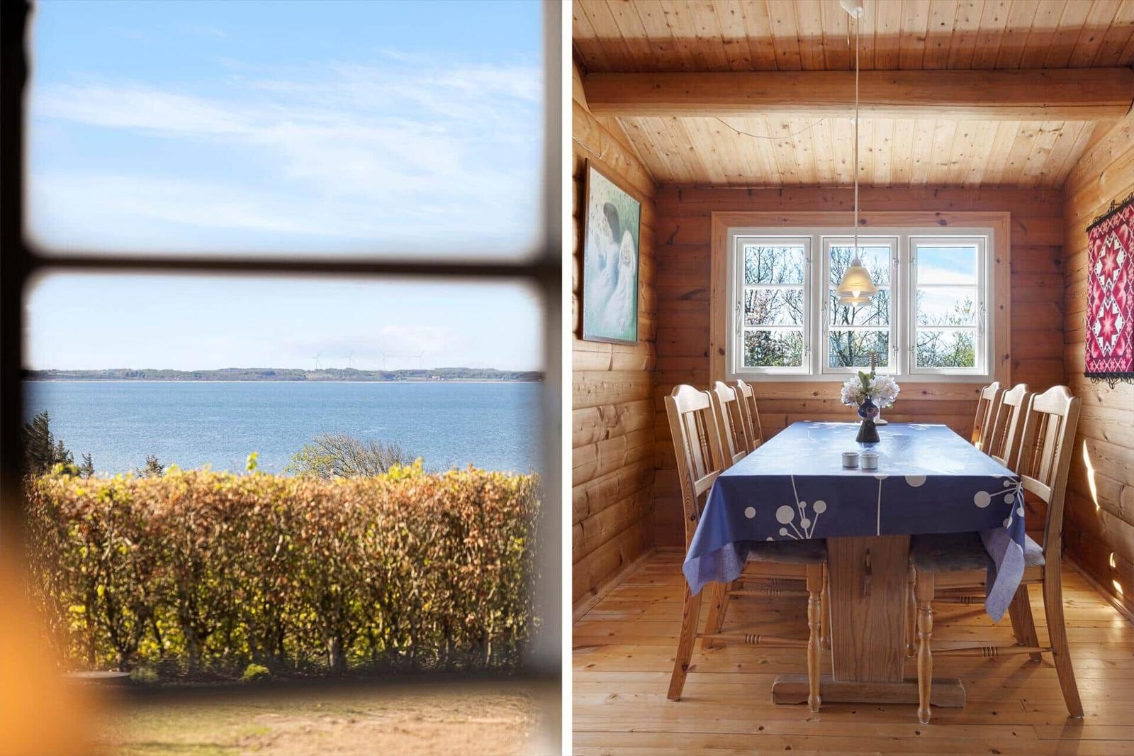 Ein Esszimmer mit Holzwänden und einem Fenster mit Blick aufs Wasser.