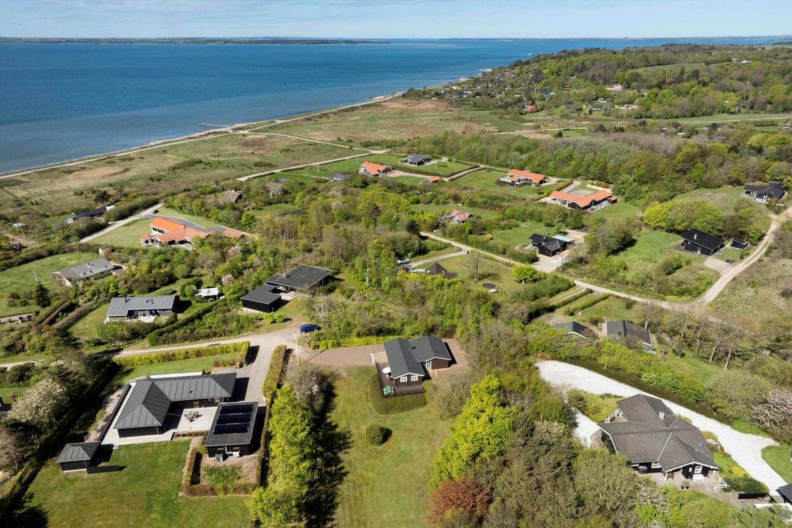 Aerial view of holiday homes near a large body of water surrounded by greenery.