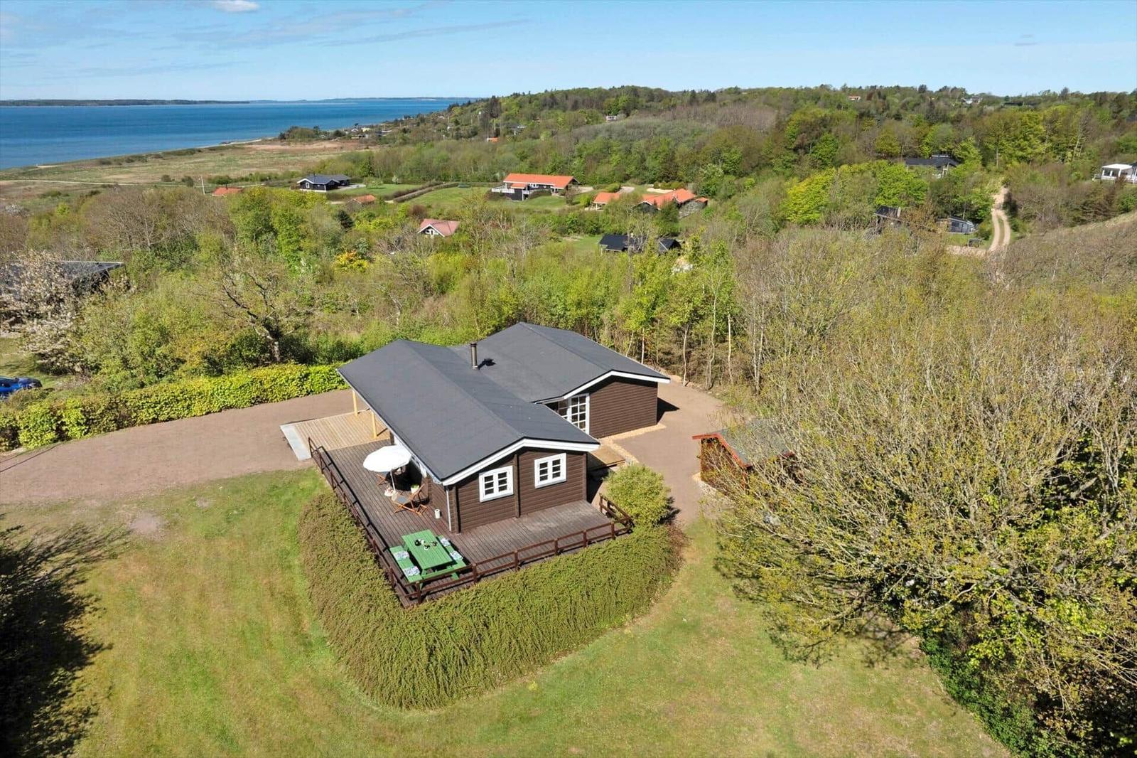 Holzhäuschen mit Terrasse, Grillplatz und Blick aufs Meer.