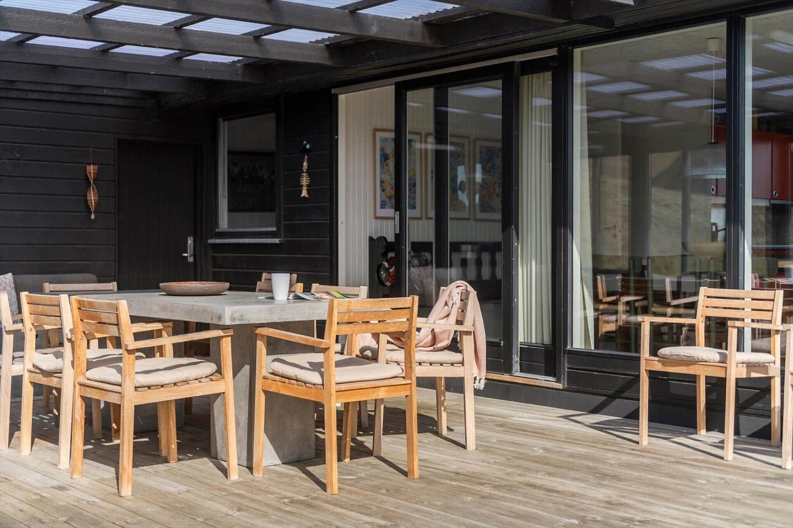 Terrasse mit Holztisch und Stühlen unter Dach