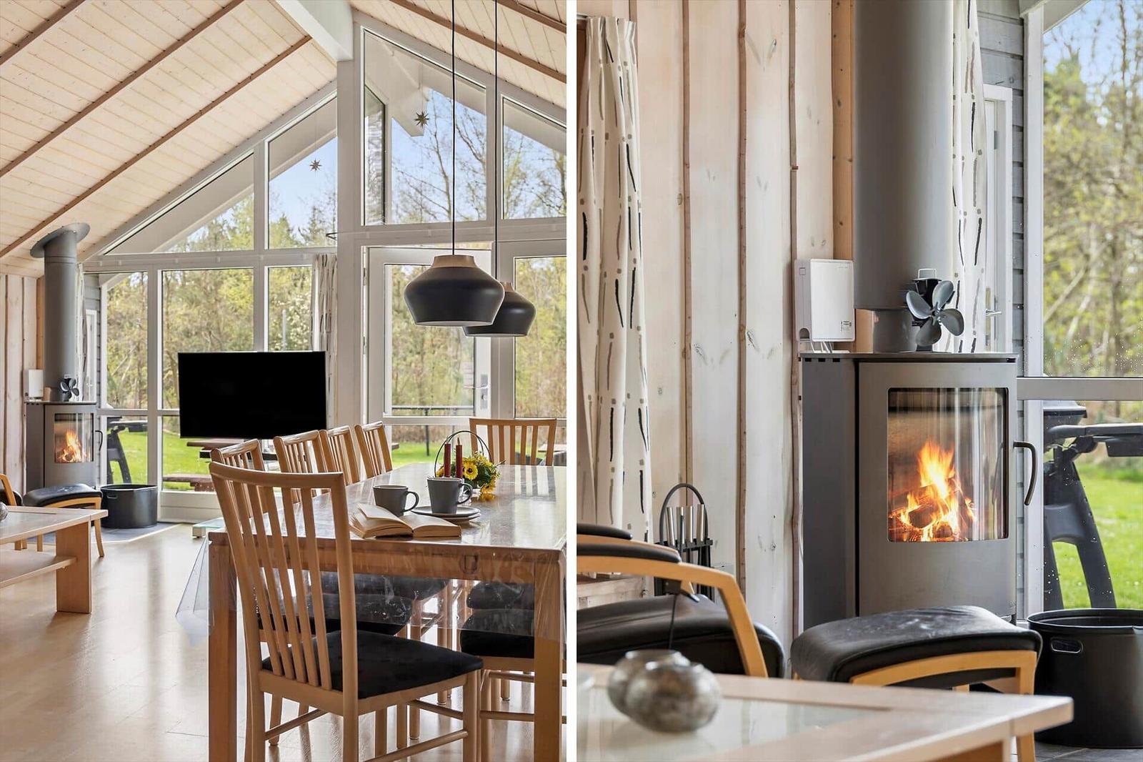 Haus mit Holzverkleidung, Kamin und großem Fensterblick auf den Garten.
