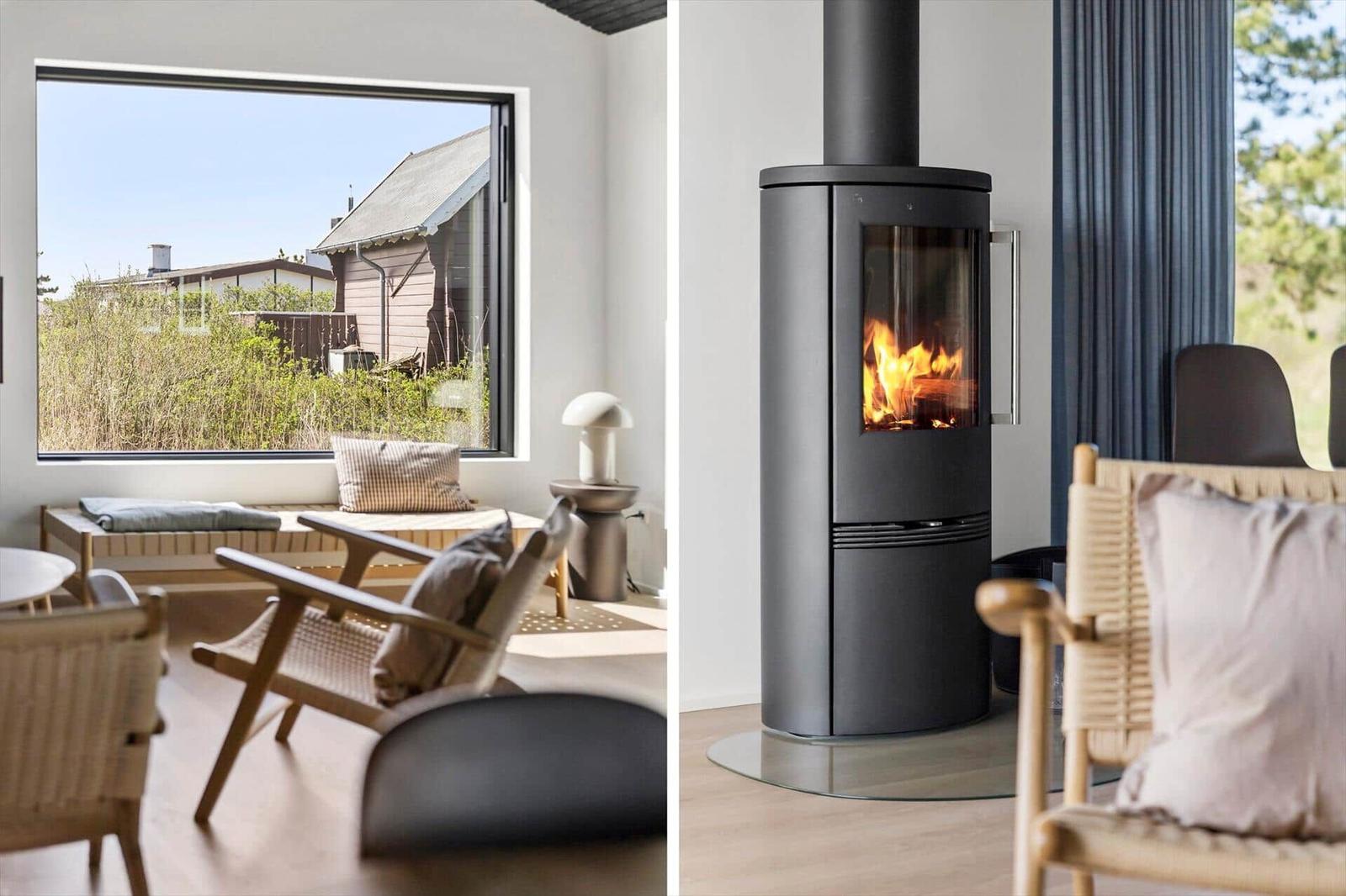 Wohnzimmer mit Kamin und großem Fensterblick auf Außenbereich