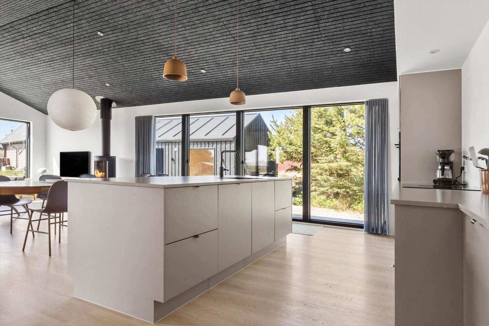 Küche mit Insel, Glasfront und Holzboden. Modern eingerichtet mit Küchengeräten.