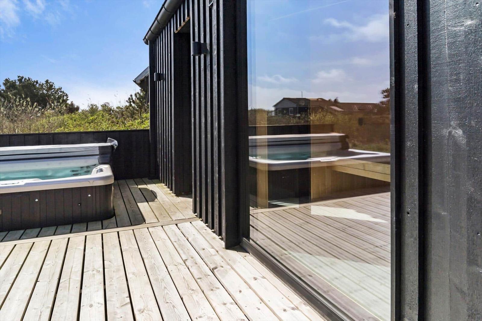 Terrasse mit Whirlpool und Glasfront zur Aussicht