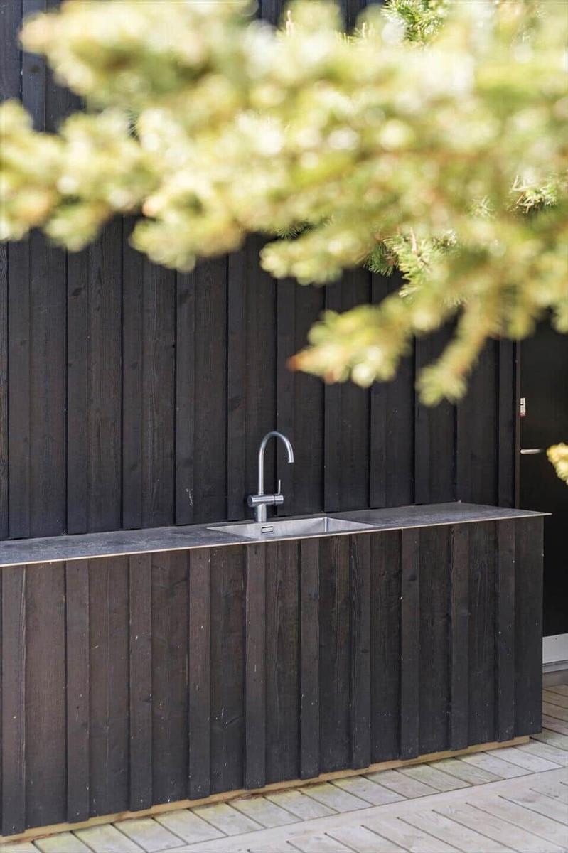 Außendusche mit Edelstahlwaschbecken und dunklem Holzgestell