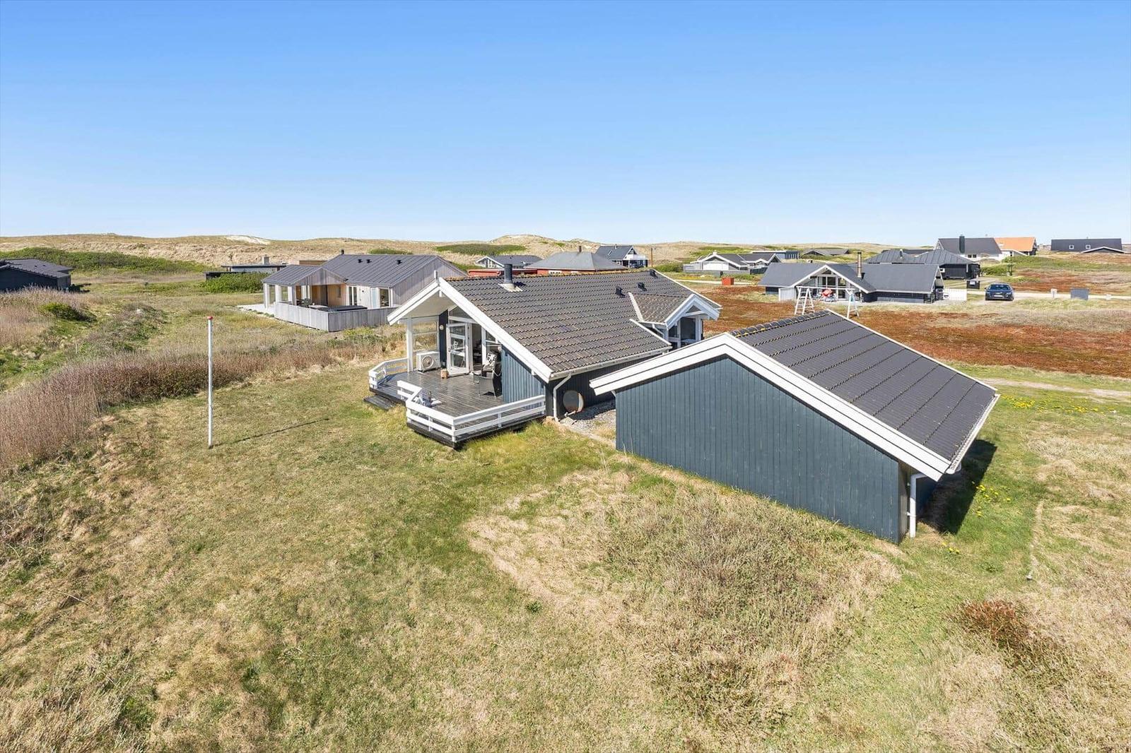 Moderne Ferienhaus mit Terrasse und Garage auf grünem Grundstück
