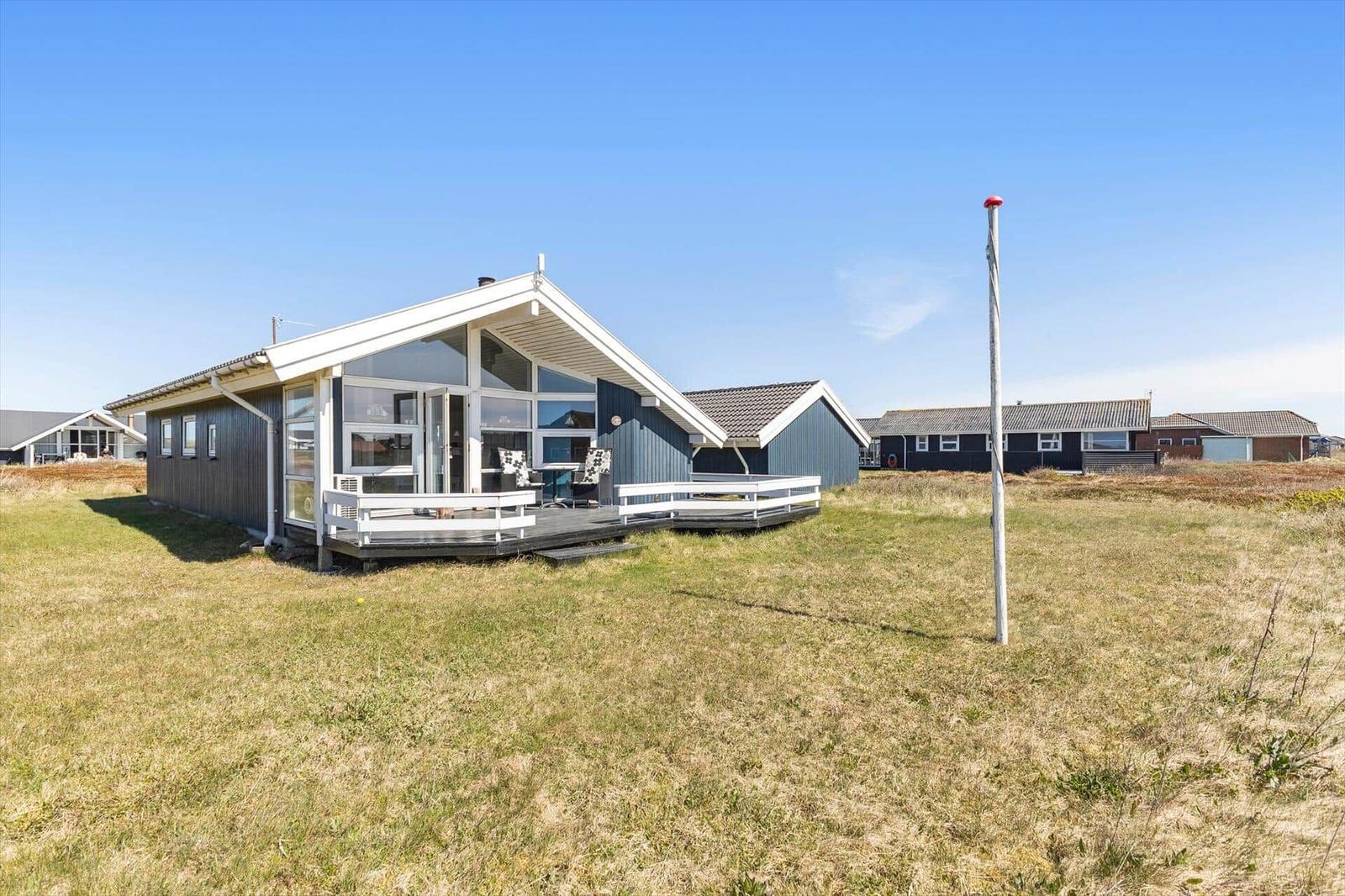 Moderne Strandvilla mit Terrasse und großem Fensterbereich.