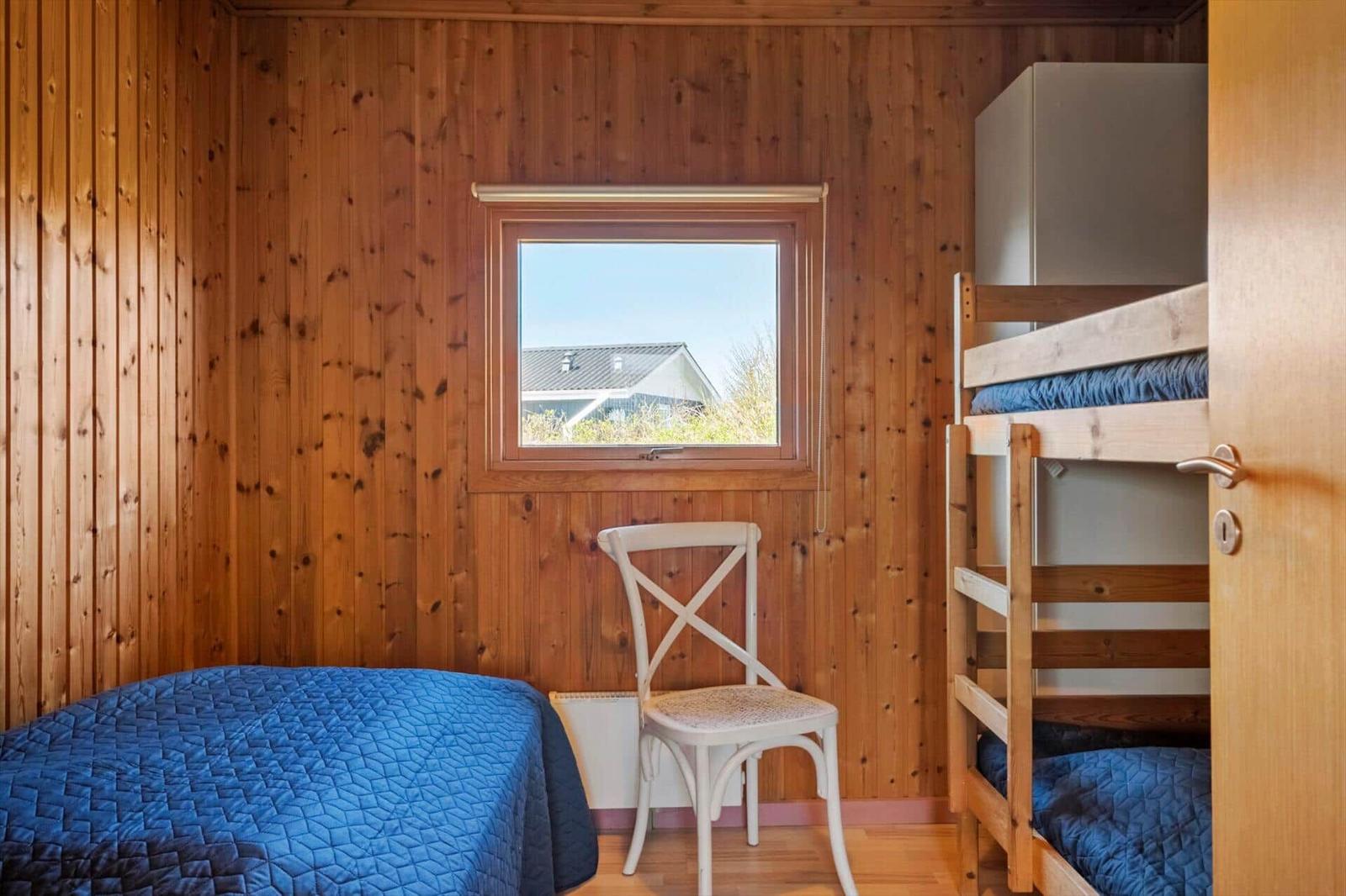 Zimmer mit Doppelbett, Etagenbett und Fenster mit Blick.