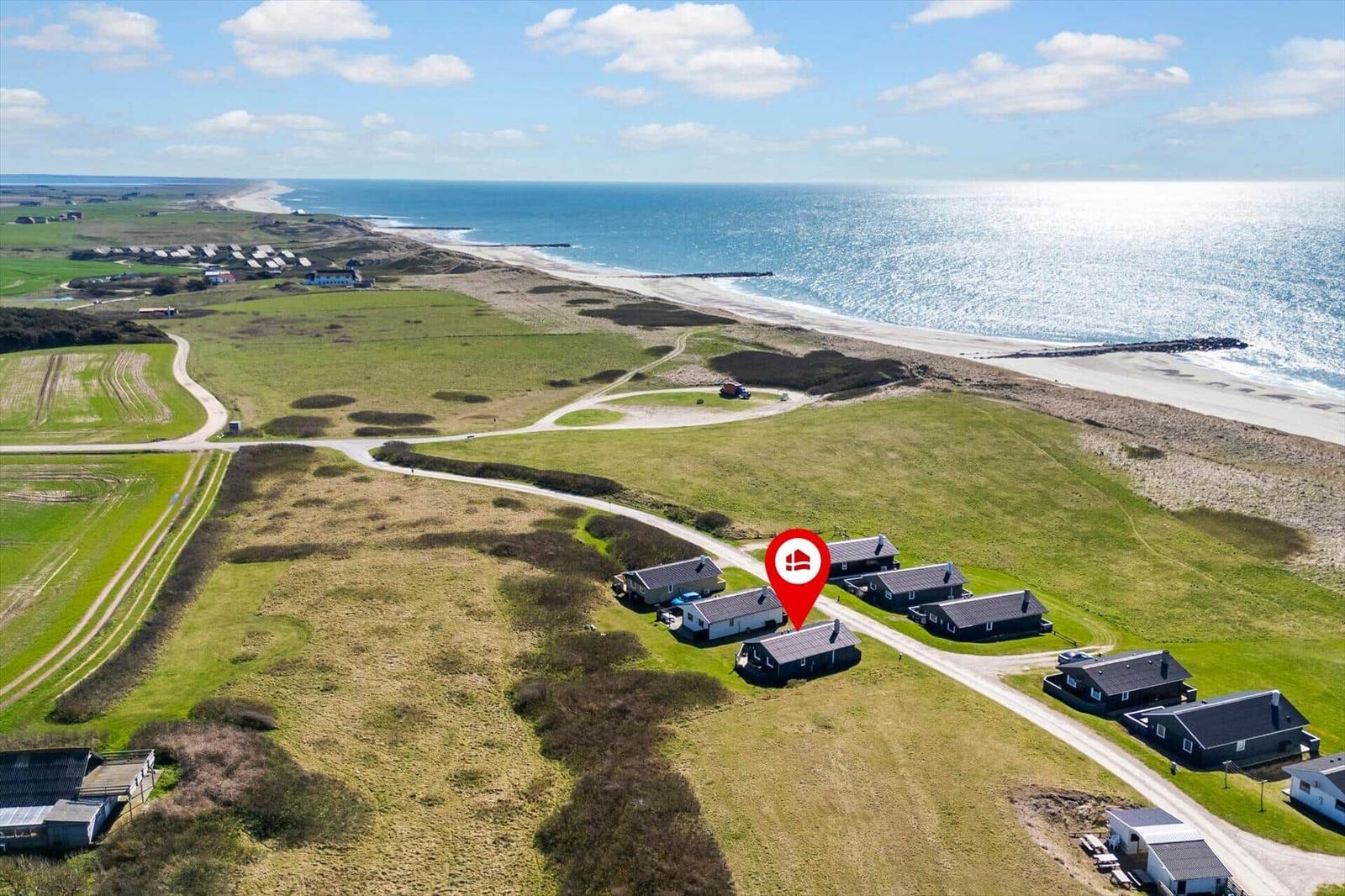 Haus in grüner Landschaft mit Blick auf das Meer und Strand
