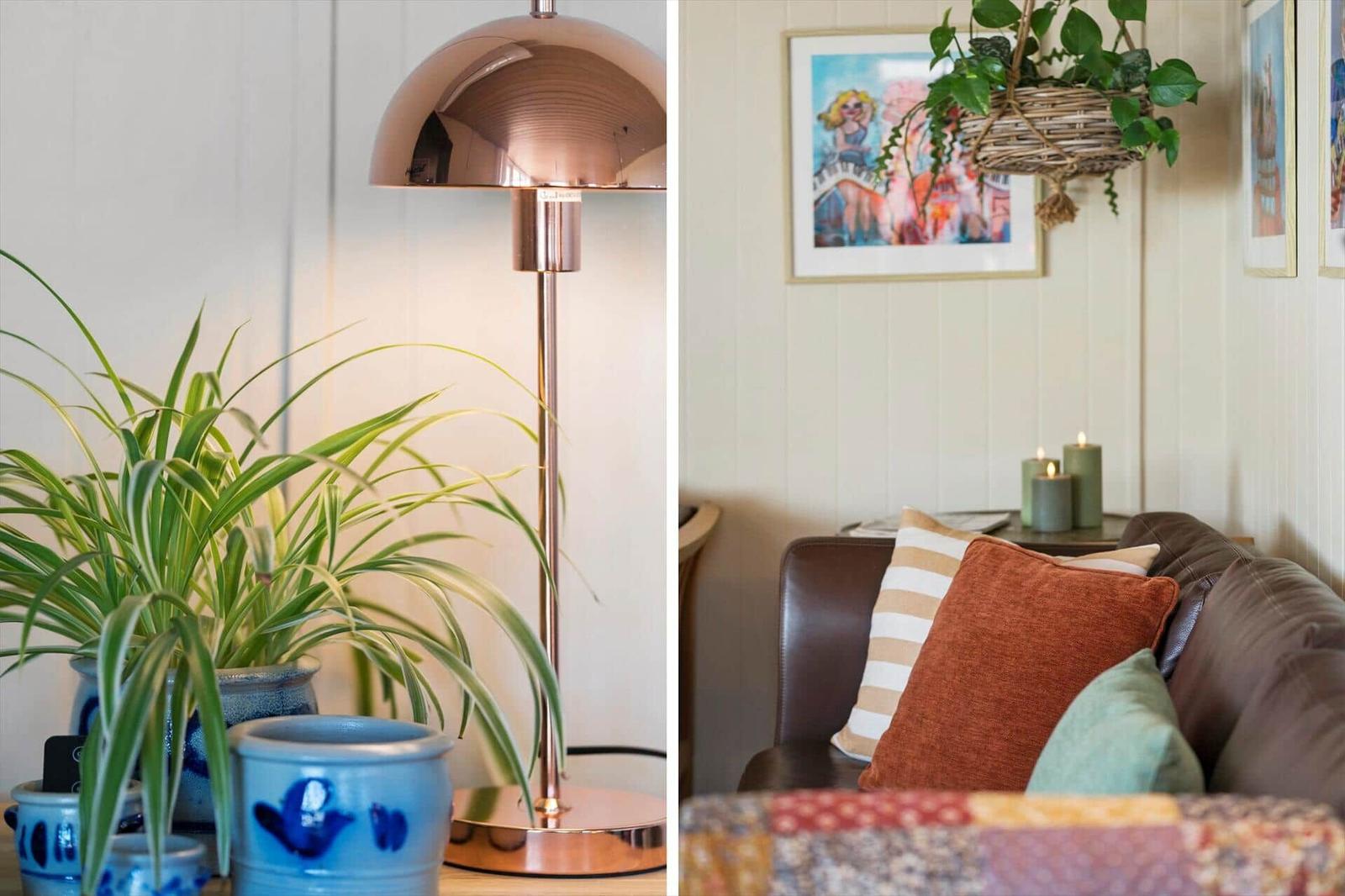 Lampe und Pflanzen auf Tisch, Sofa mit Kissen und Wandbild