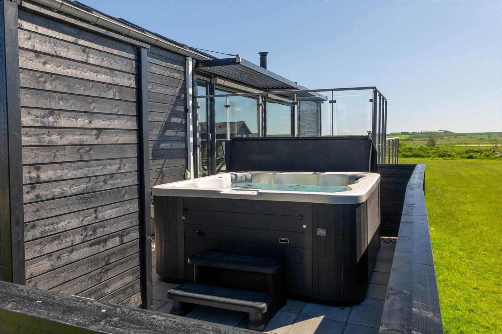 Hochwertige Whirlpool-Terrasse mit Blick auf grünes Feld