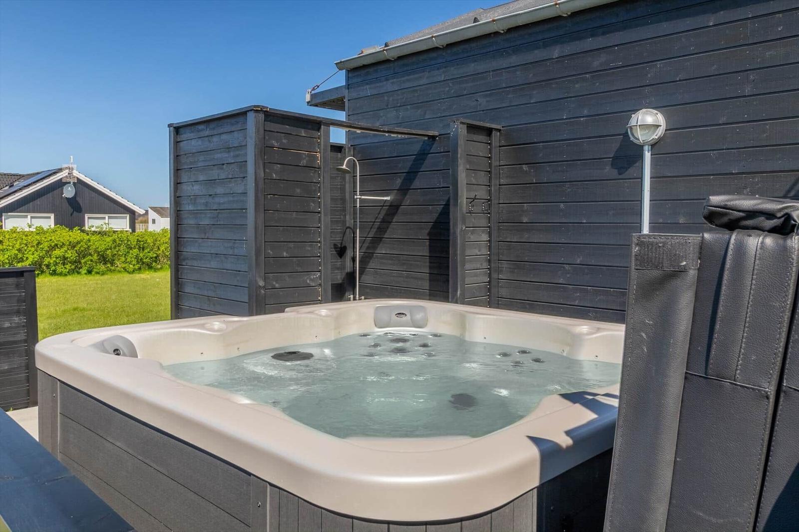 Außenwhirlpool mit Duschmöglichkeit und Gartenbereich