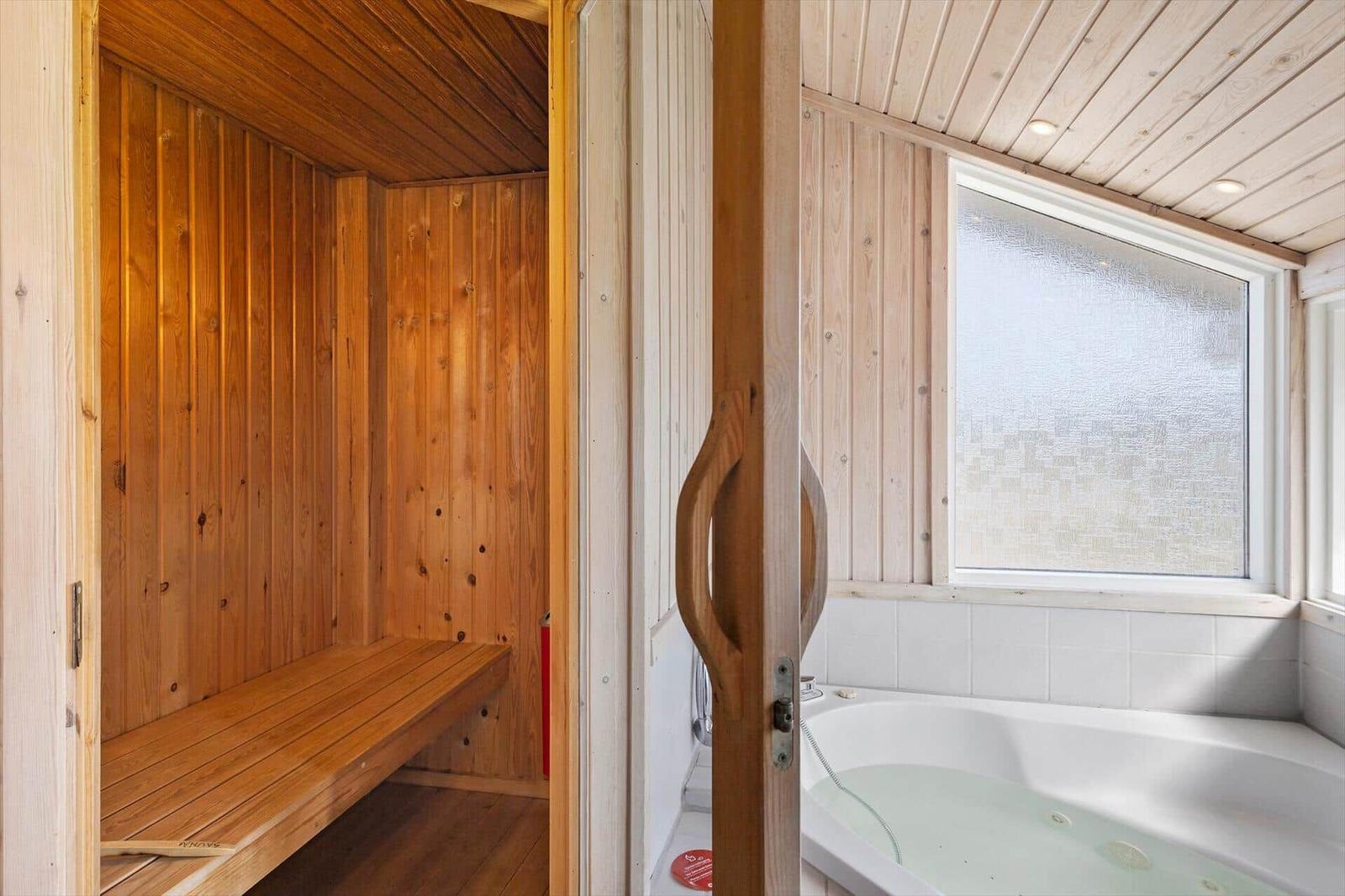 Sauna mit Holzbank und Badewanne mit Fenster