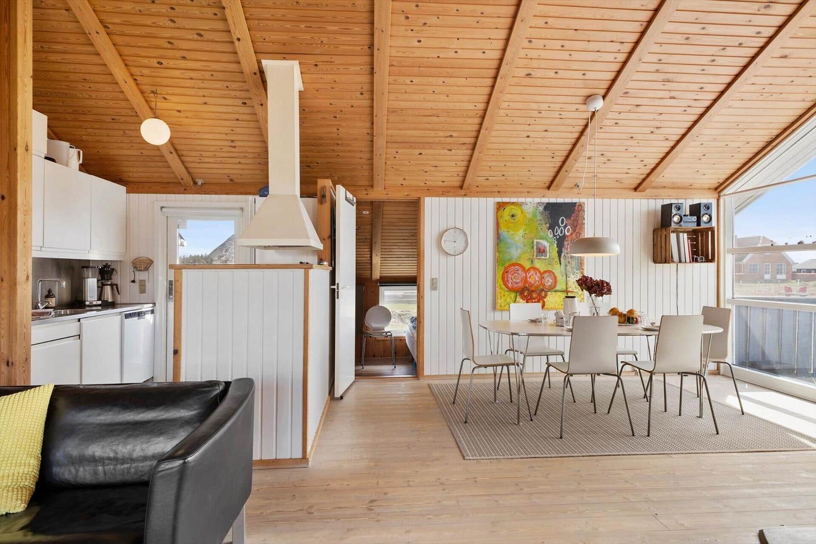 Küche, Essbereich und Wohnbereich mit Holzdecke und Fenster. Moderne Einrichtung.