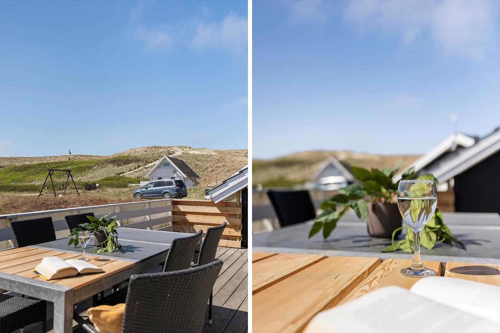 Terrasse mit Tisch, Stühlen und Blick auf Dünen und Haus