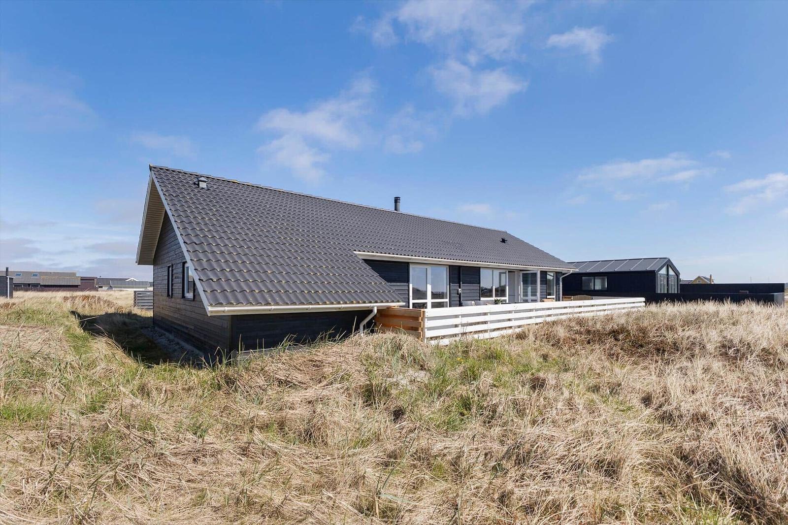 Moderne Villa mit Terrasse in Grasland unter blauem Himmel