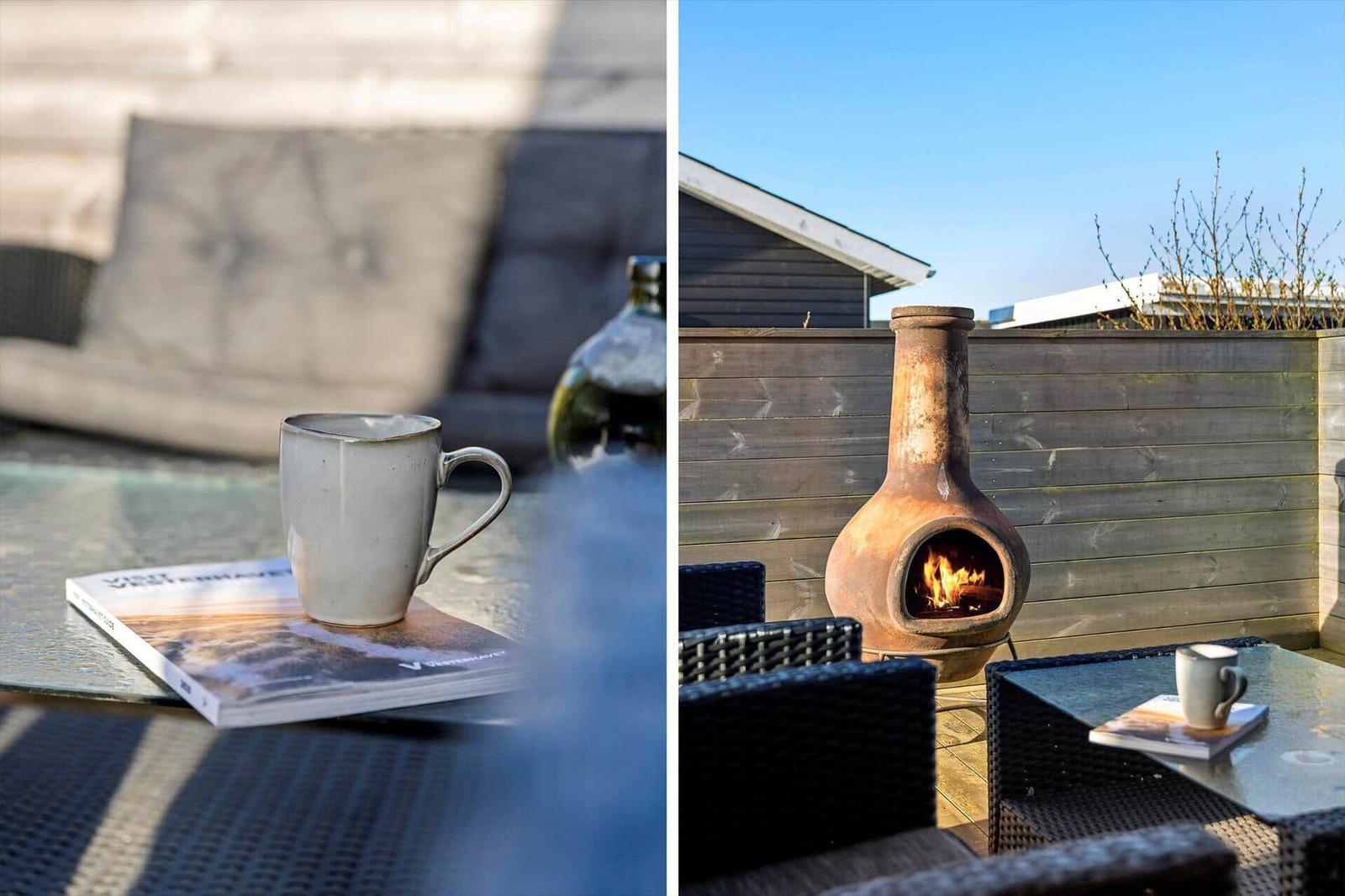 Terasse mit Feuerkamin, Sitzgelegenheiten und Tisch mit Tasse und Zeitschrift.