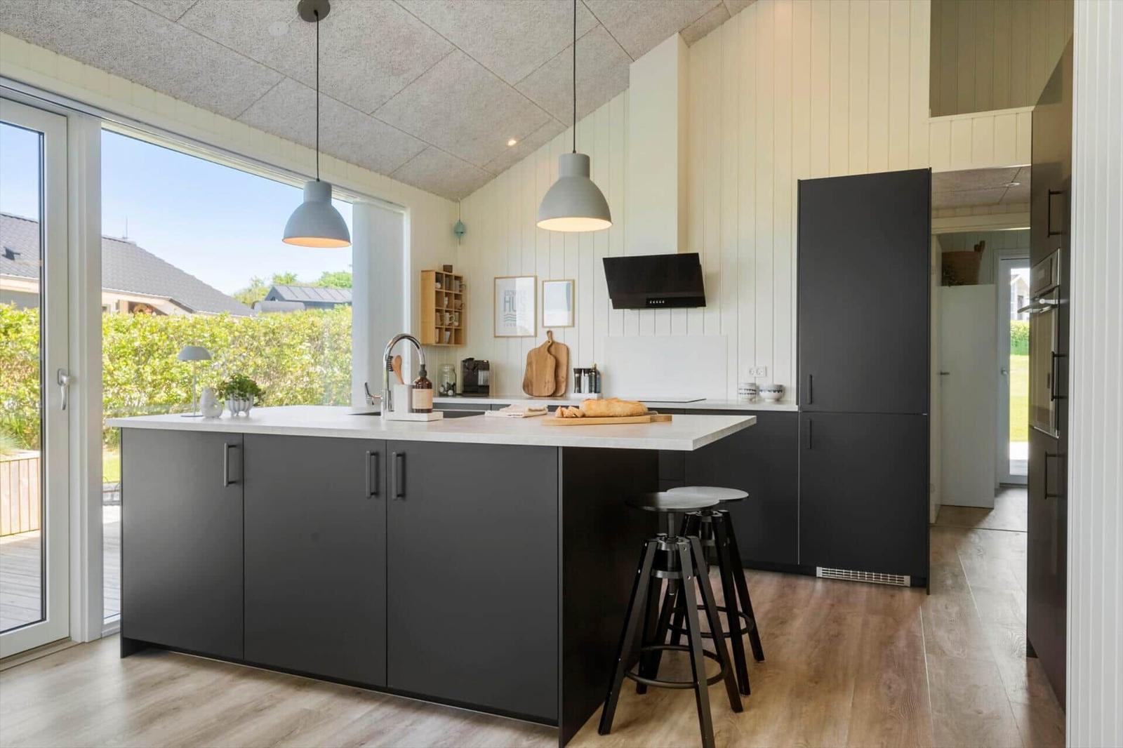 Moderne Küche mit dunklen Schränken, Arbeitsplatte und Sitzhöhe für Barhocker.