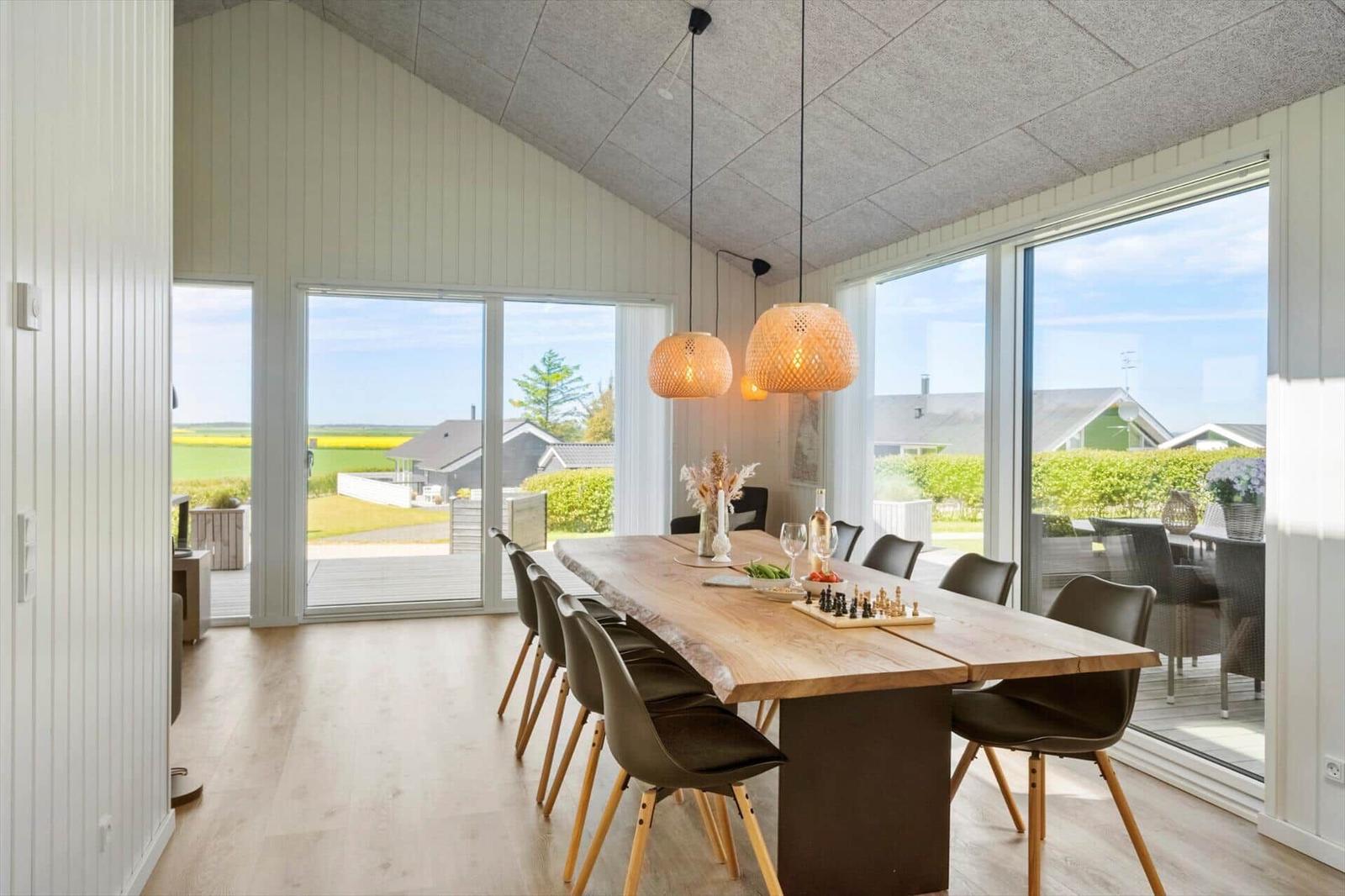 Esszimmer mit Holztisch, Stühlen und Blick auf Garten
