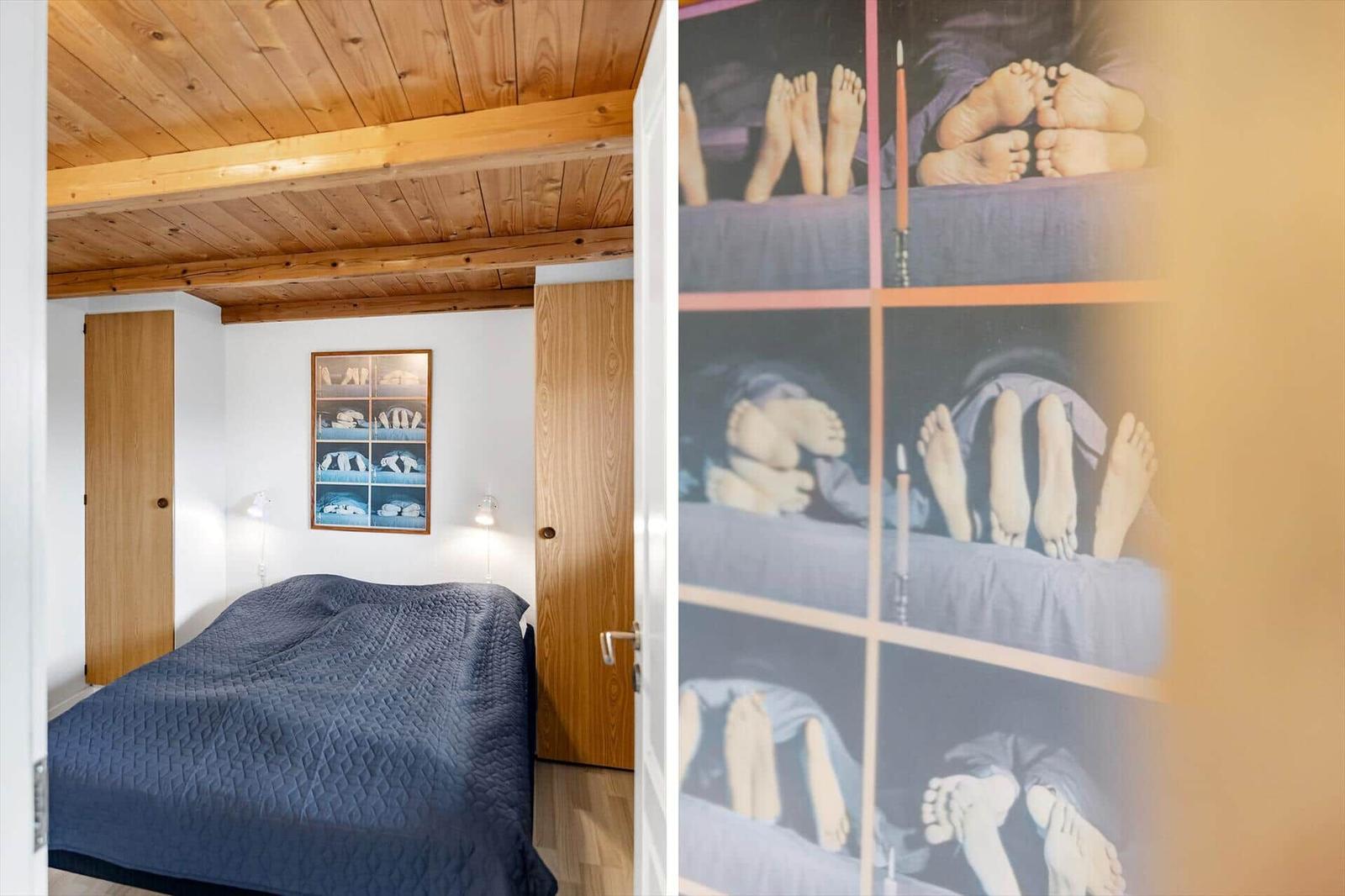 Schlafzimmer mit Holzdecke, Bett und Wandbild mit Füßen.