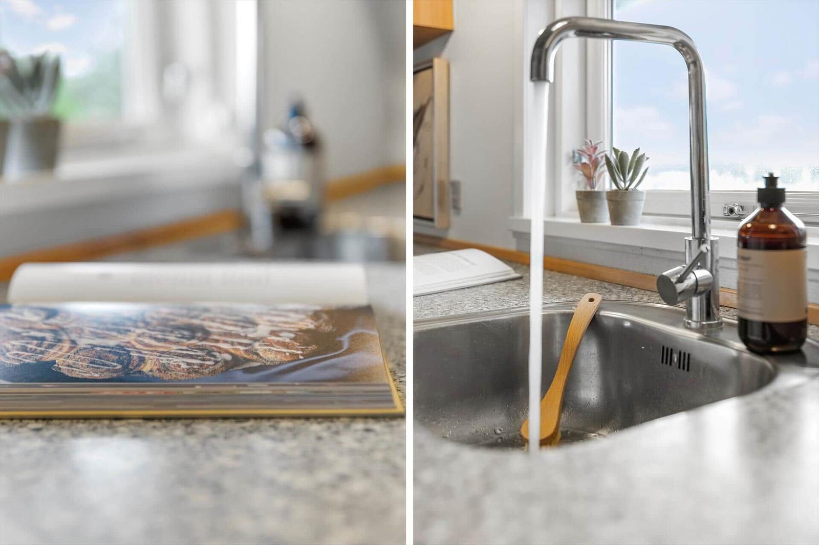 Küchenarbeitsfläche mit Kochbuch und Spüle mit laufendem Wasser.