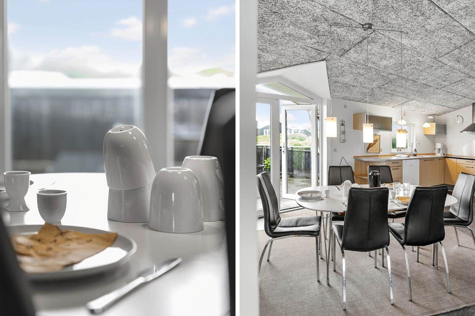 Essbereich mit Tisch, Stühlen und Küchenbereich. Fenster und Tür zeigen auf Balkon.