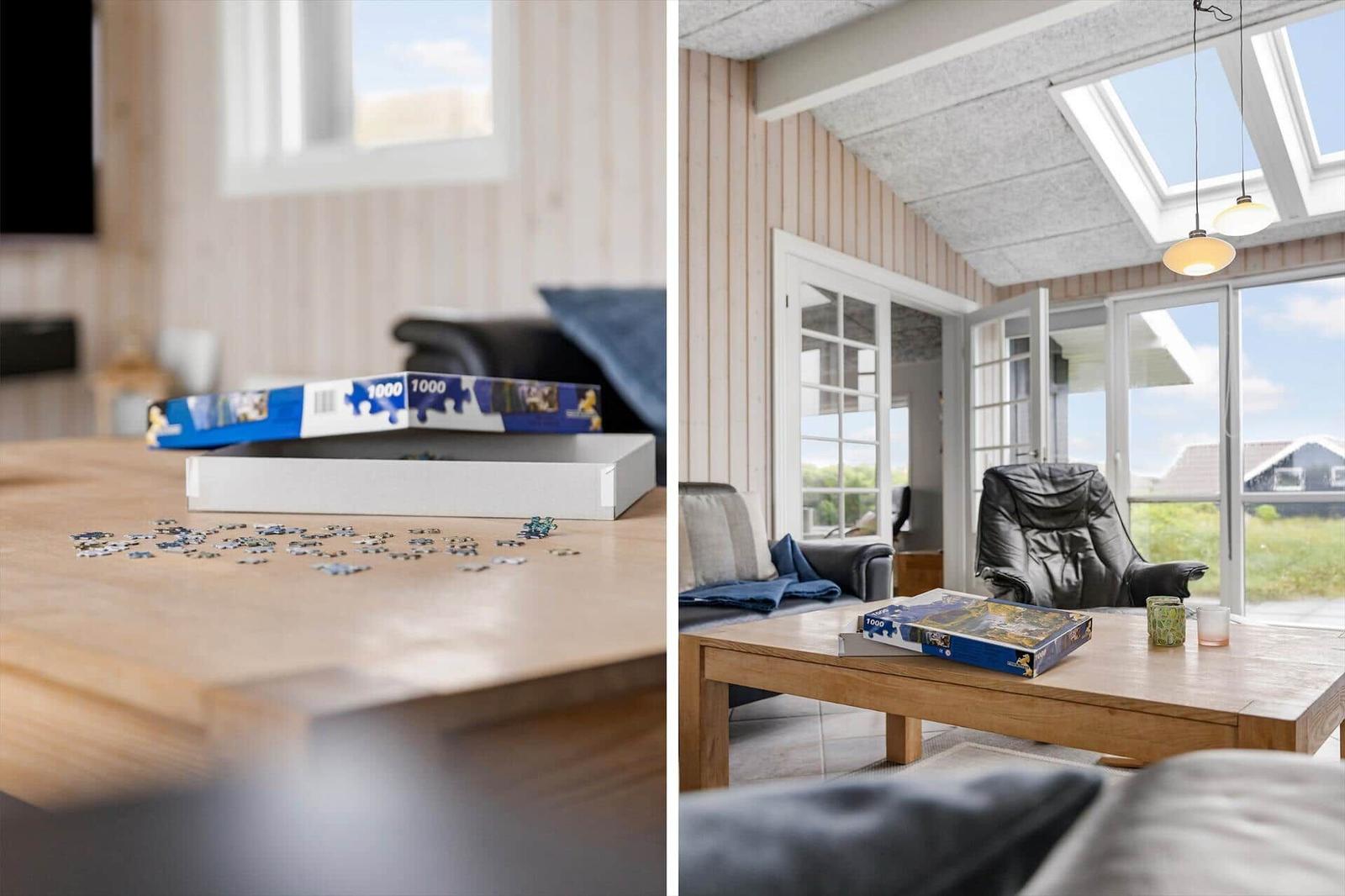 Wohnzimmer mit Holztisch, Puzzle und Blick auf die Außenterrasse.