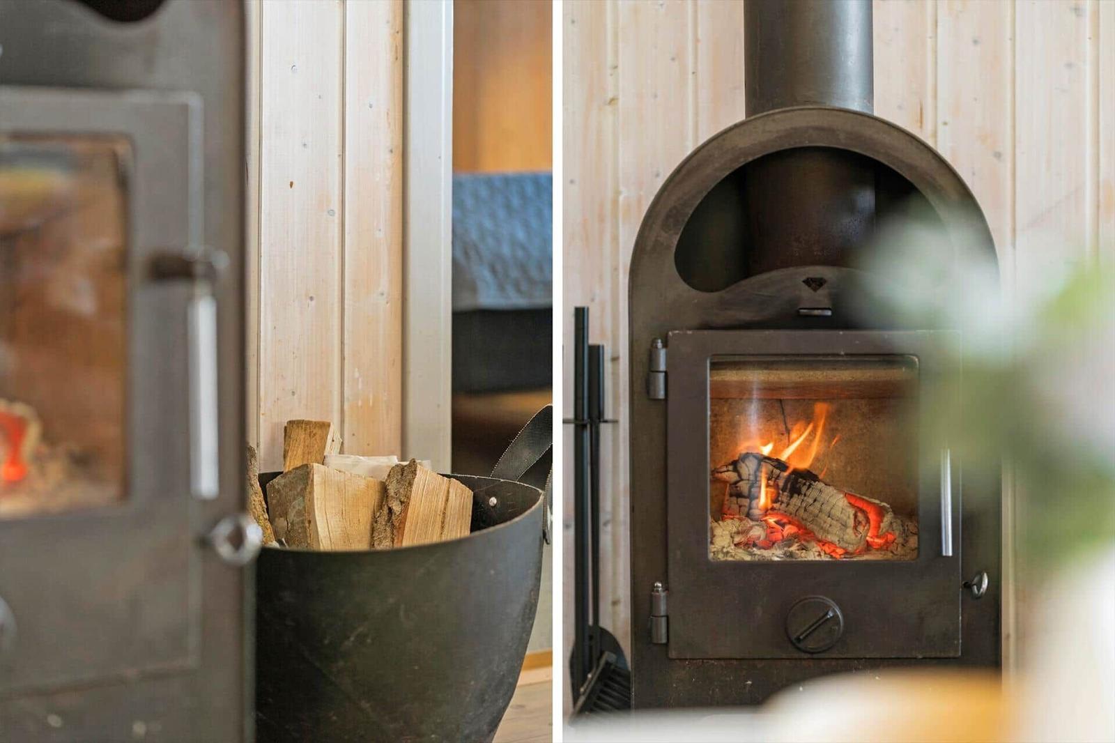 Holzofen mit brennendem Feuer und Holzstapel in rustikalem Raum.