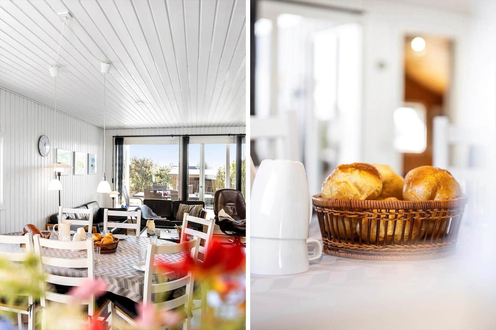 Esszimmer mit Tisch, Stühlen und Blick auf die Terrasse. Korb mit Brot auf der Arbeitsfläche.