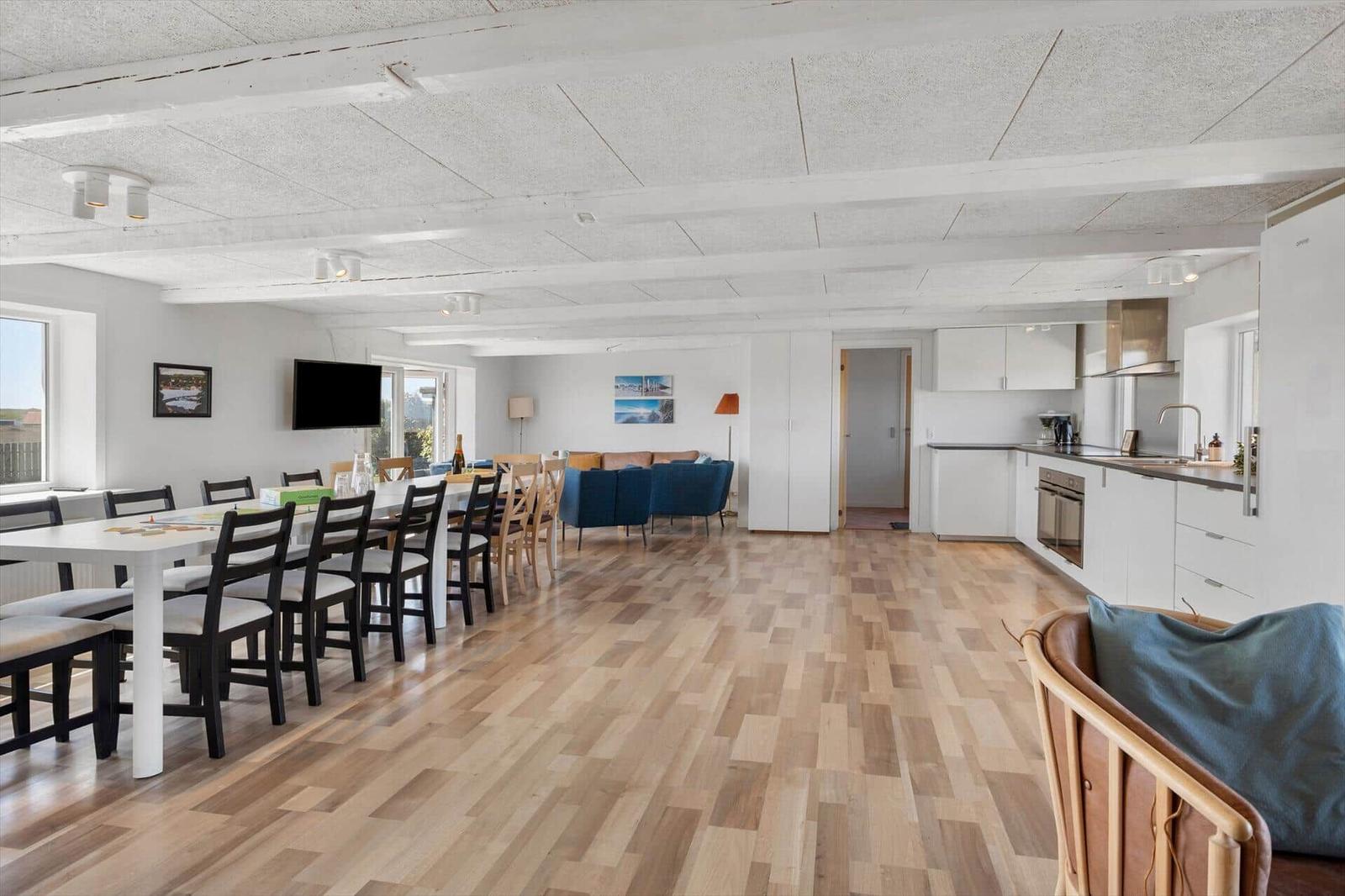 Großes Wohn- und Esszimmer mit Holzboden, Küchenzeile und Essbereich.