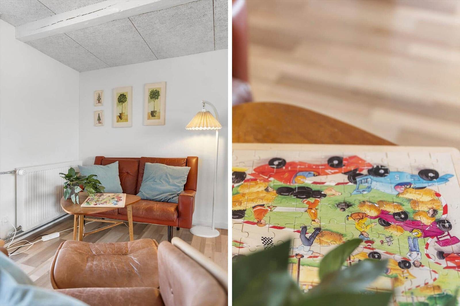 Raum mit braunem Sofa und Lampen. Puzzle mit Rennwagen auf Tisch.