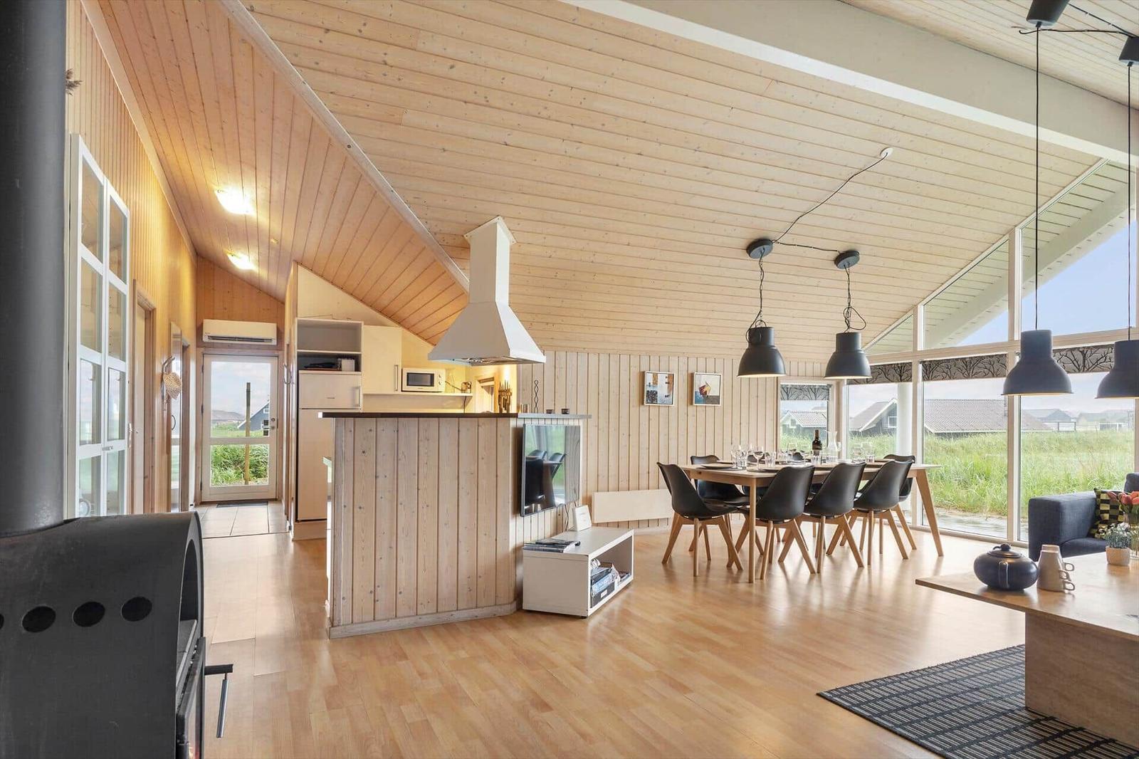 Moderne Küche mit Essbereich und großem Fensterblick auf die Landschaft.