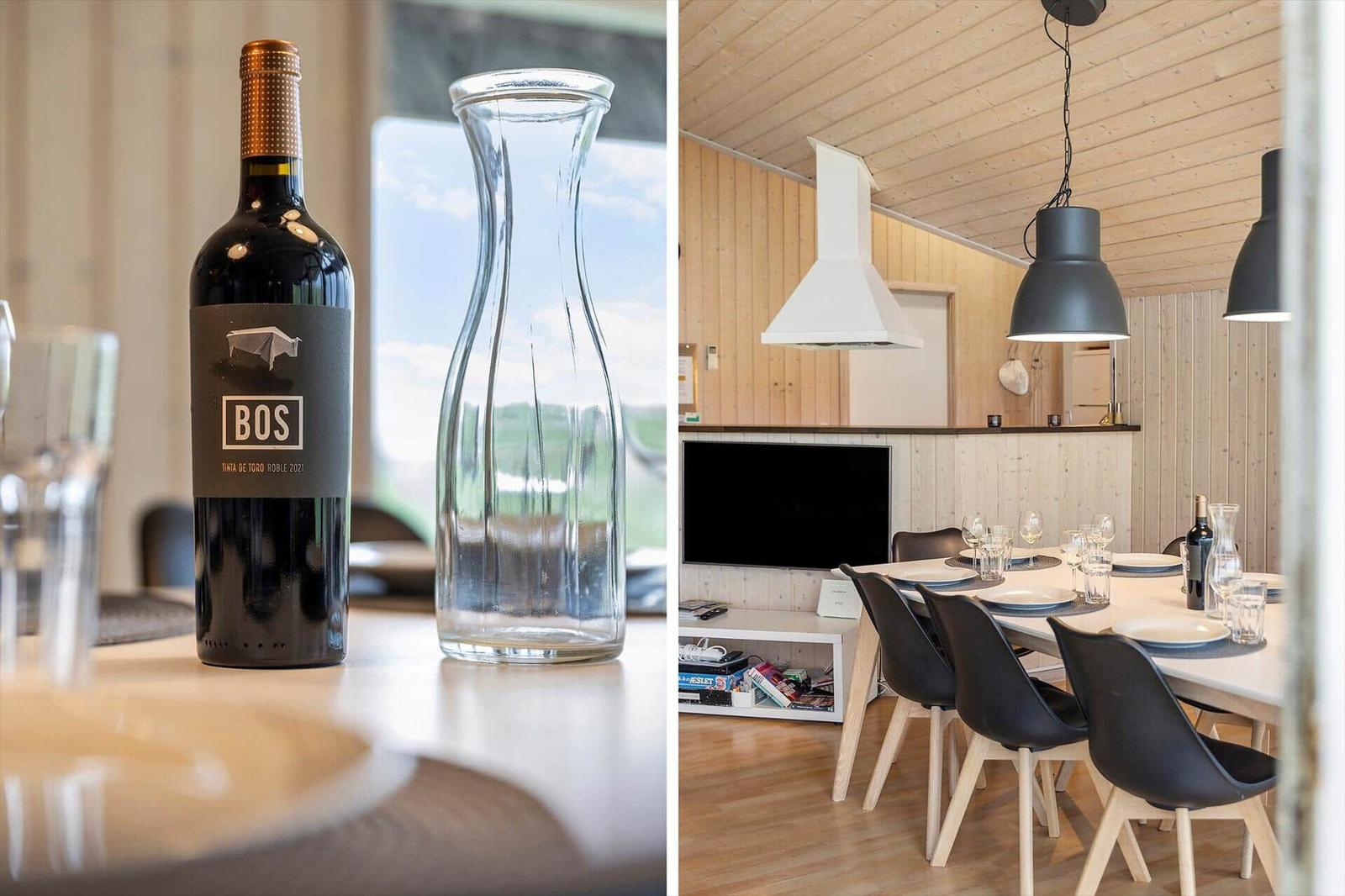 Ein Tisch mit Weinflasche und Karaffe. Esszimmer mit Holzwand und schwarzen Stühlen.