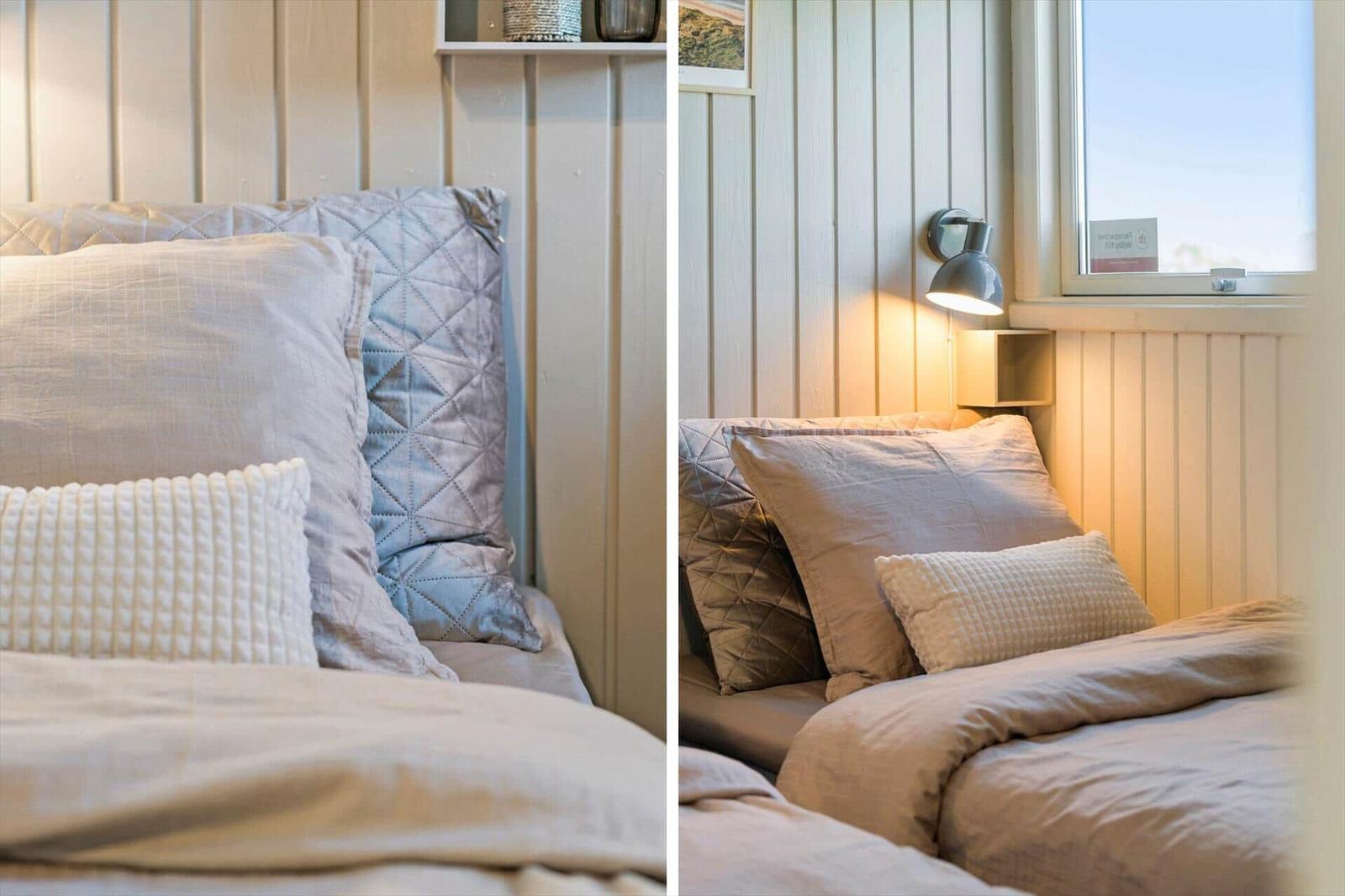 Schlafzimmer mit Bett, Kissen und Fenster. Wandbeleuchtung und Holzwand.