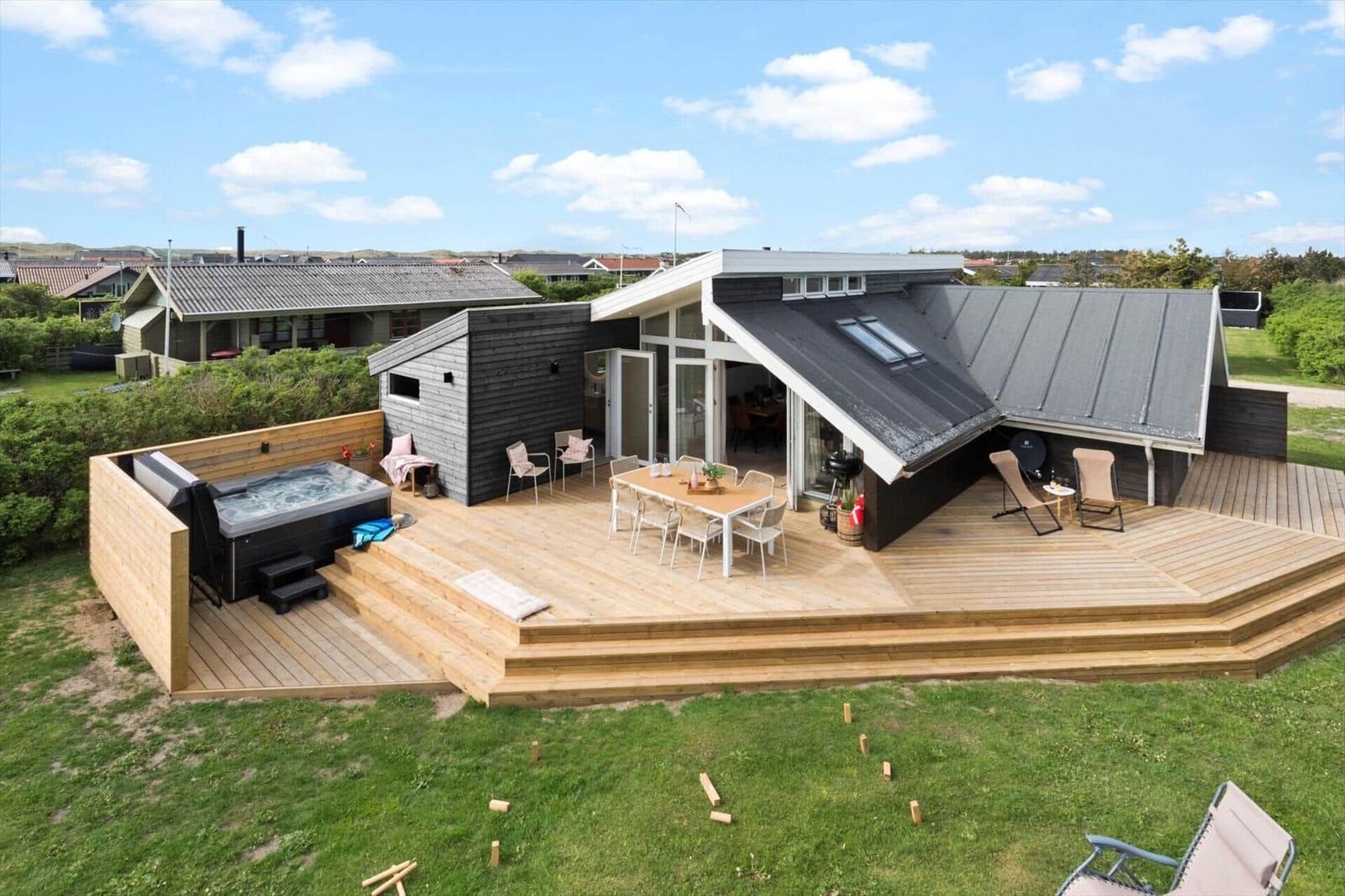 Moderne Ferienwohnung mit großem Holzdeck, Whirlpool und Essbereich.