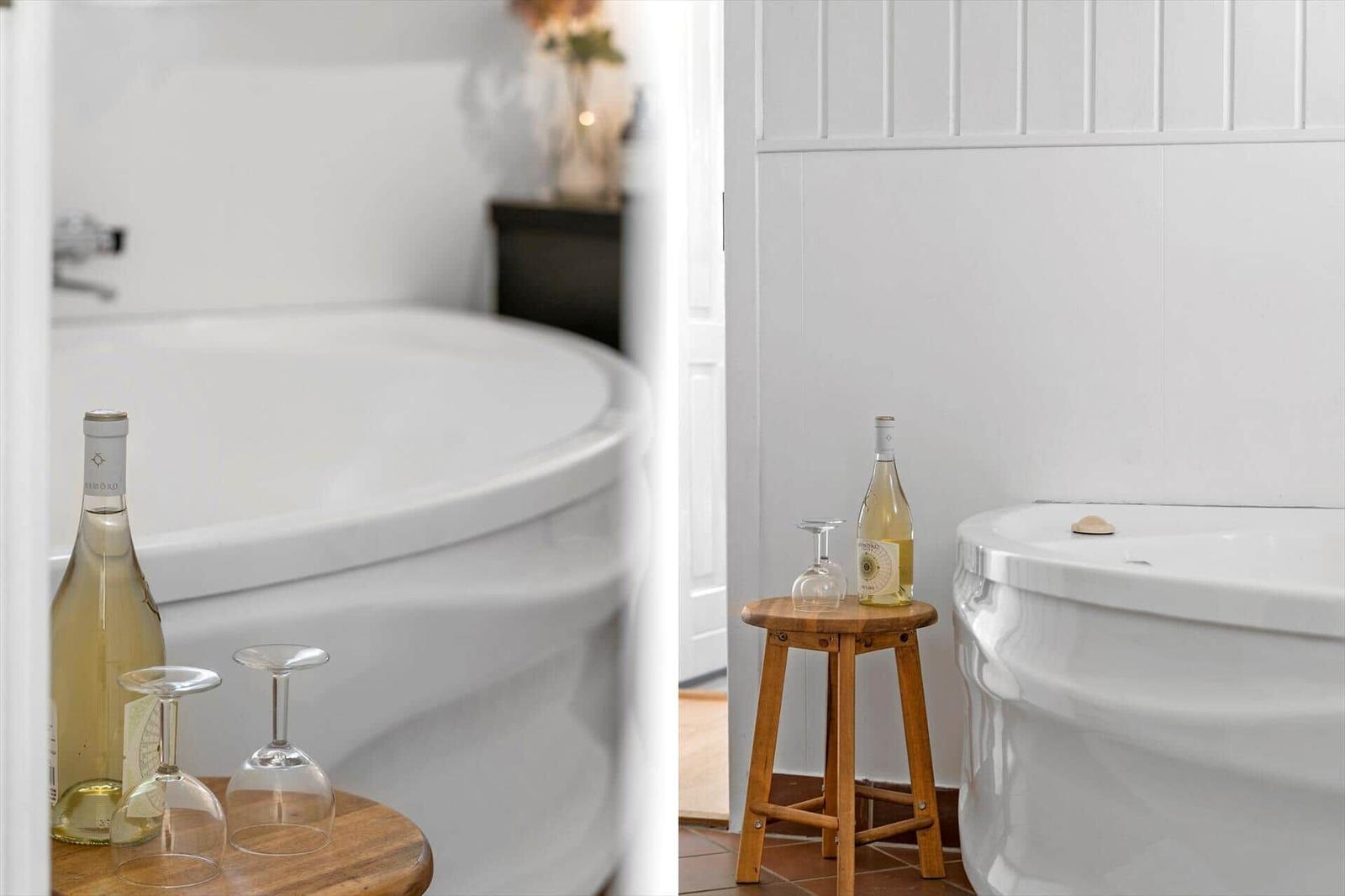 Bad mit Whirlpool, Weinflasche und Gläsern auf Holztisch