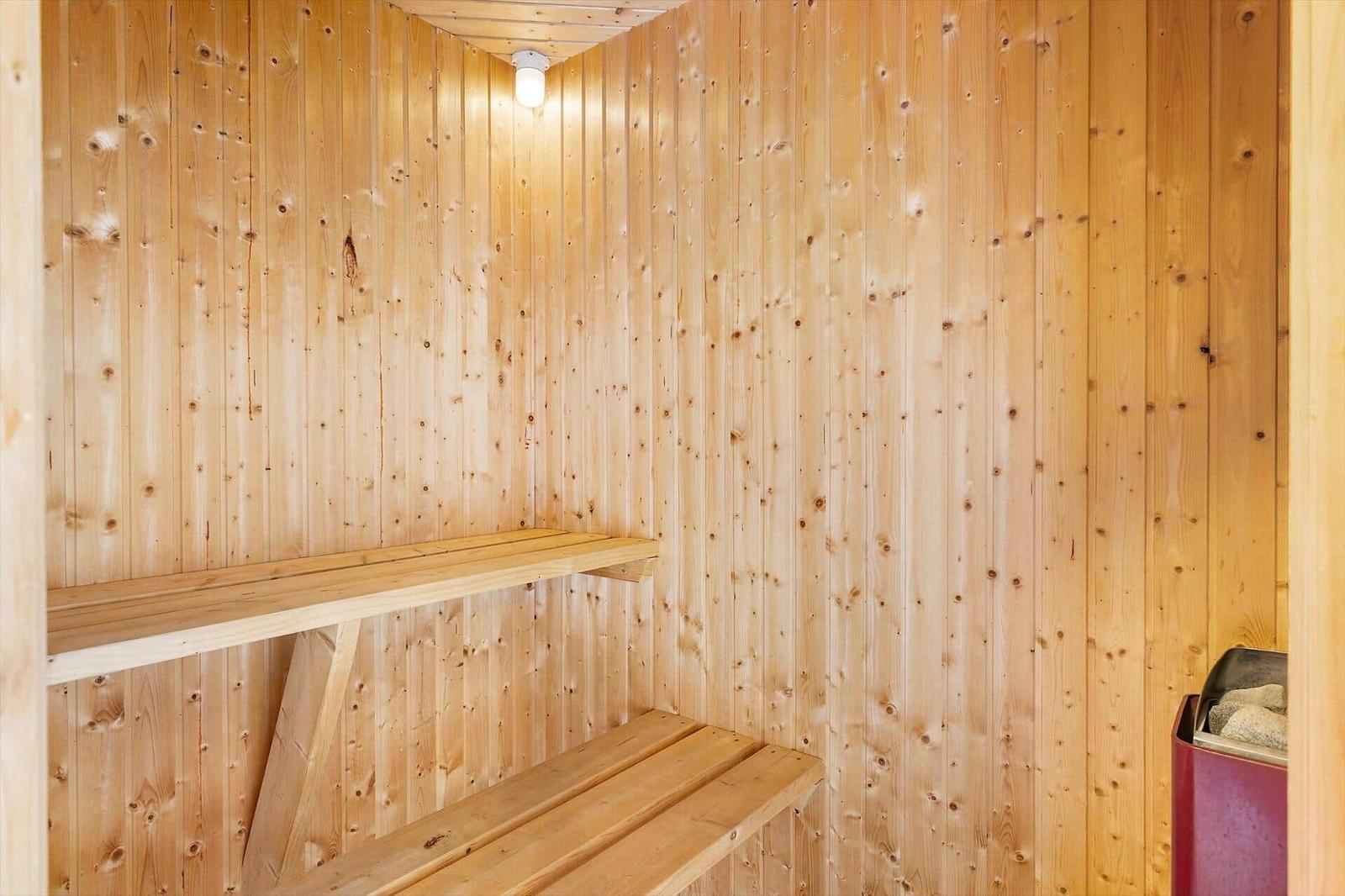 Sauna mit Holzwandverkleidung und Sitzbänken.