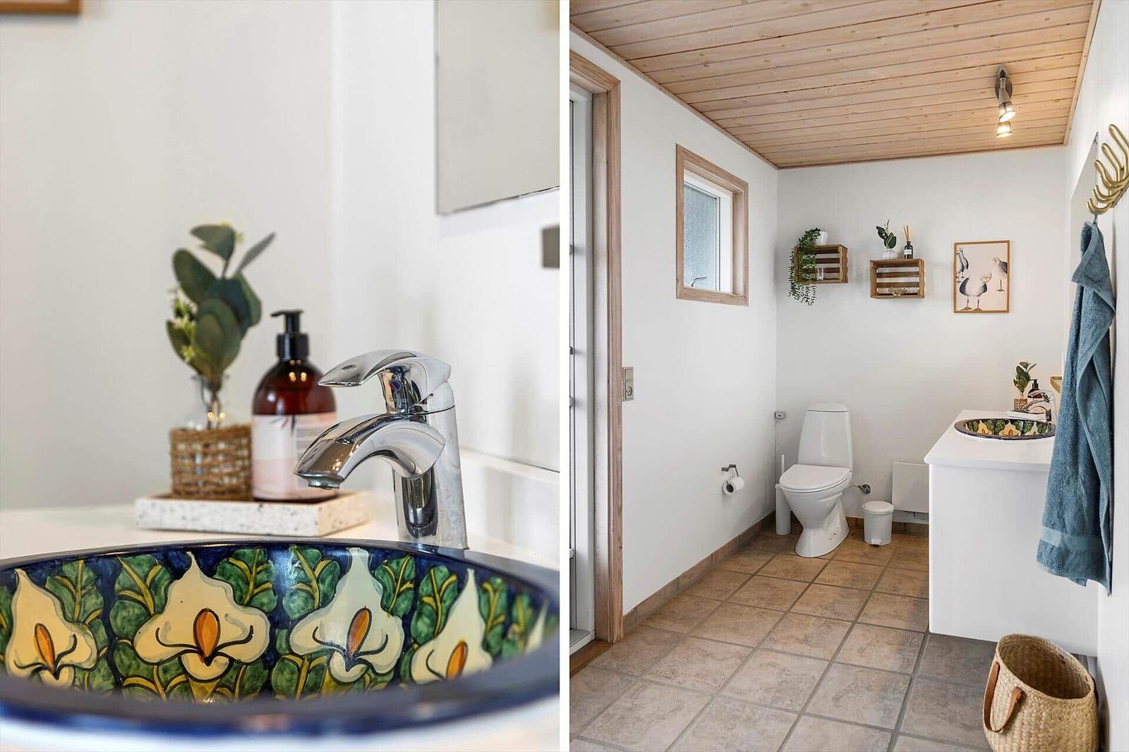 Badezimmer mit dekorativem Waschbecken, Toilette und Holzdecke.