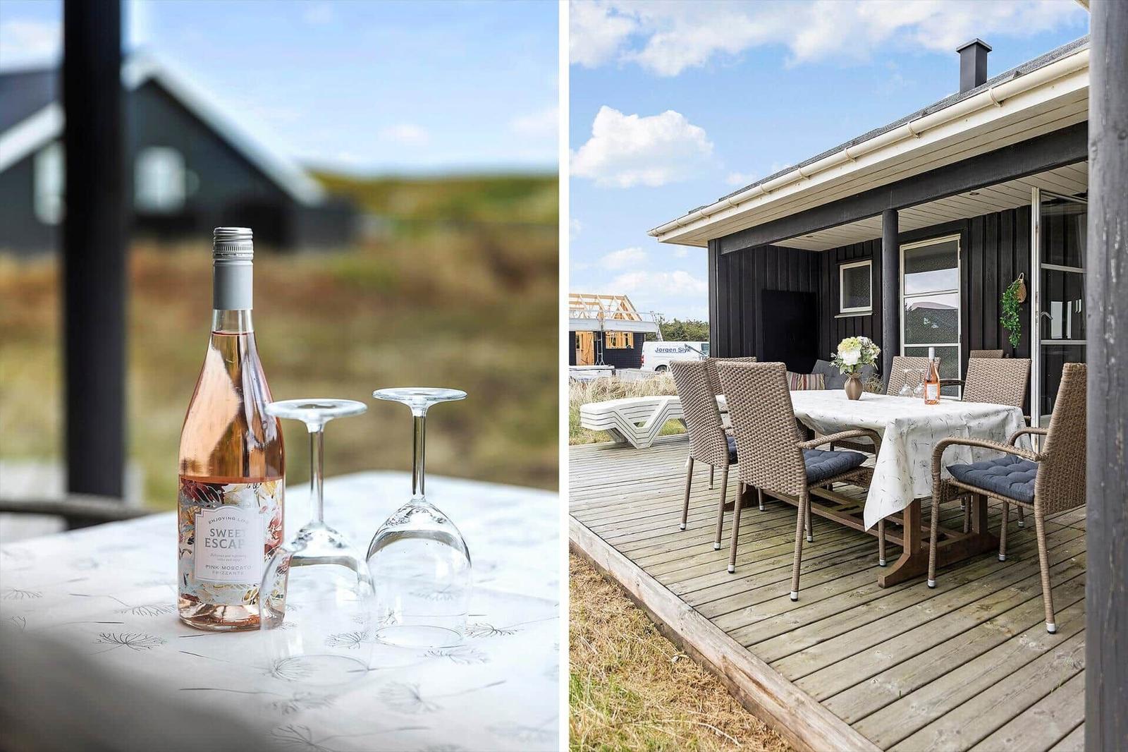 Auf der Terrasse steht ein gedeckter Tisch mit Stühlen. Im Hintergrund ist ein Haus zu sehen.