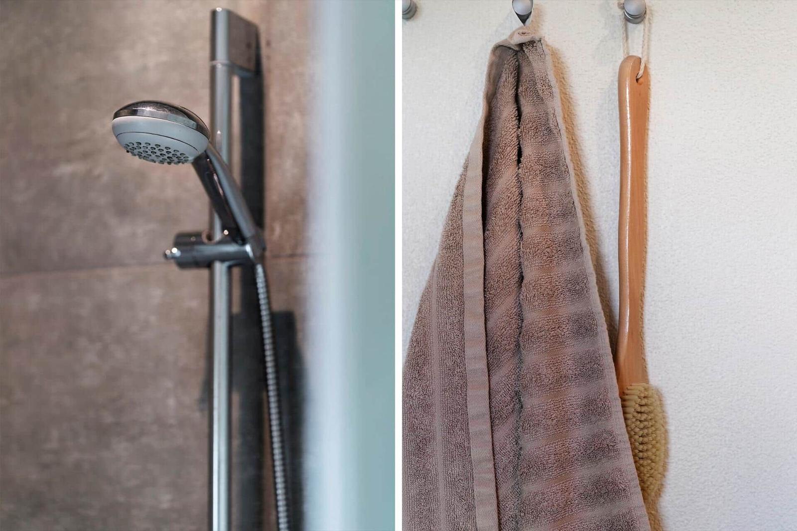 Duschbrause und Handtuch an der Wand