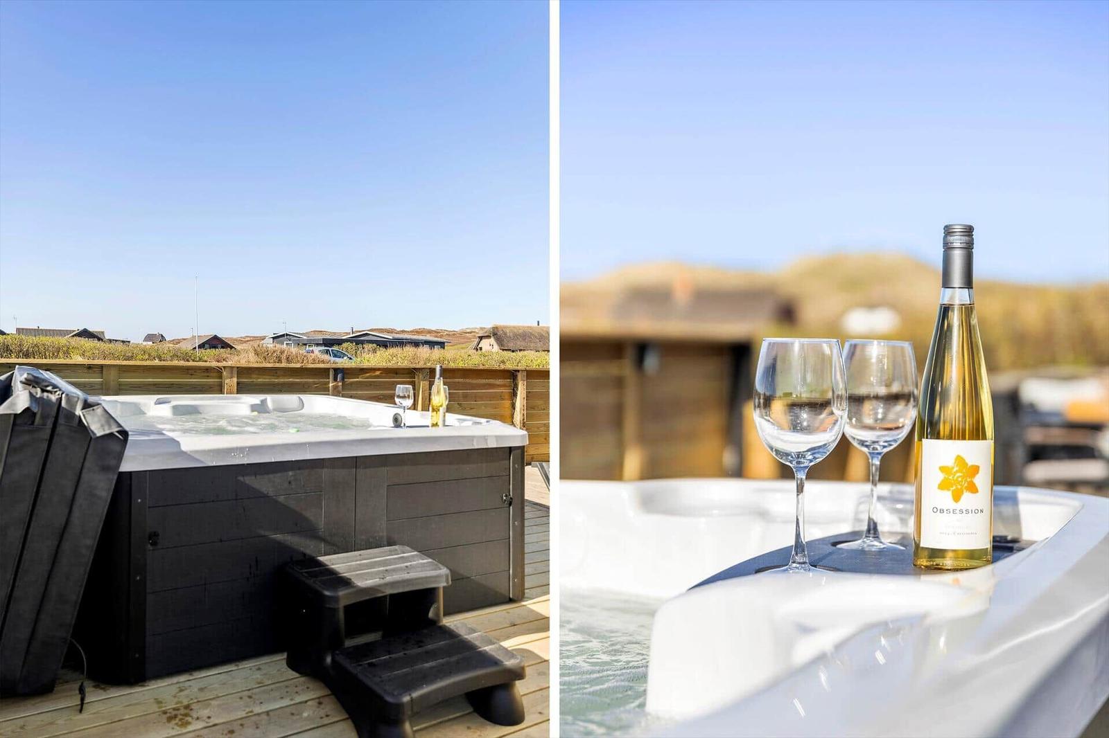 Whirlpool auf Terrasse mit Blick auf Landschaft und zwei Gläser Weißwein.