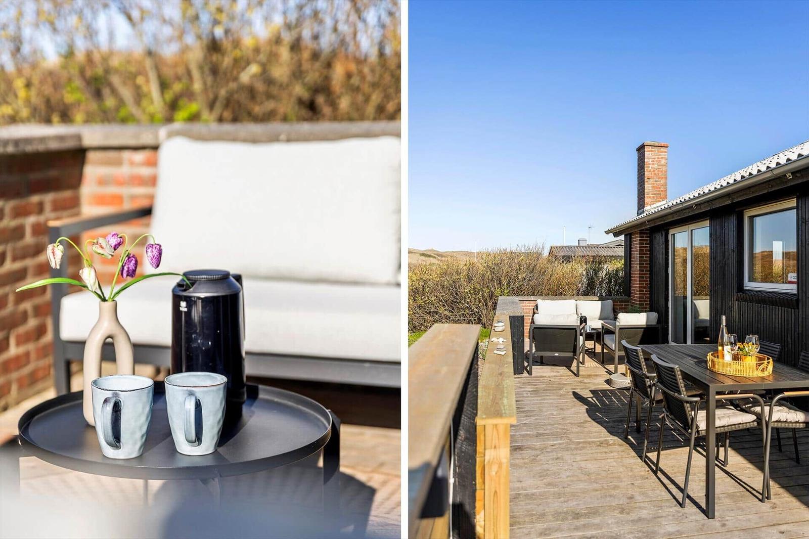 Terrasse mit Sitzgelegenheiten und Tisch. Hintergrund: Garten und Haus.