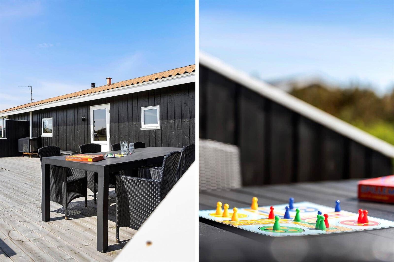 Terrasse mit Tisch und Stühlen. Spielbrett mit Figuren darauf.