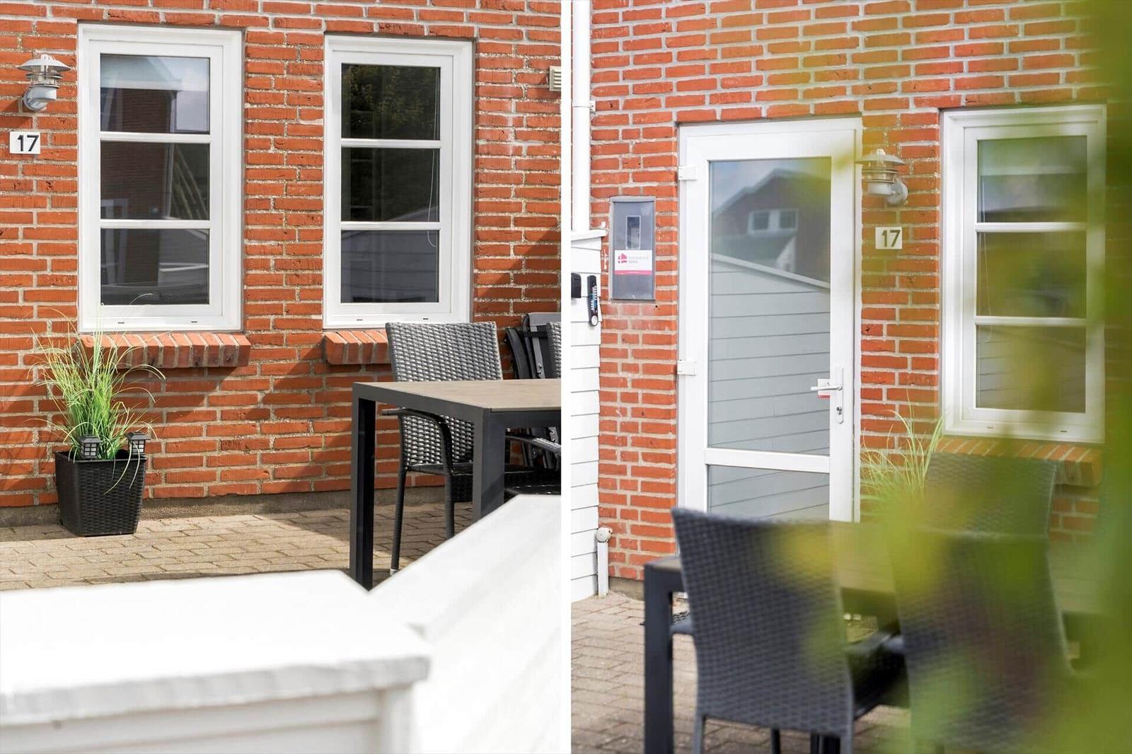 Roter Backsteinbau mit Terrasse, Tisch, Stühlen und Eingangstür mit Hausnummer 17.