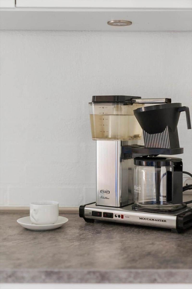 Eine Kaffeemaschine mit Wasserspender und Tasse auf der Arbeitsfläche.