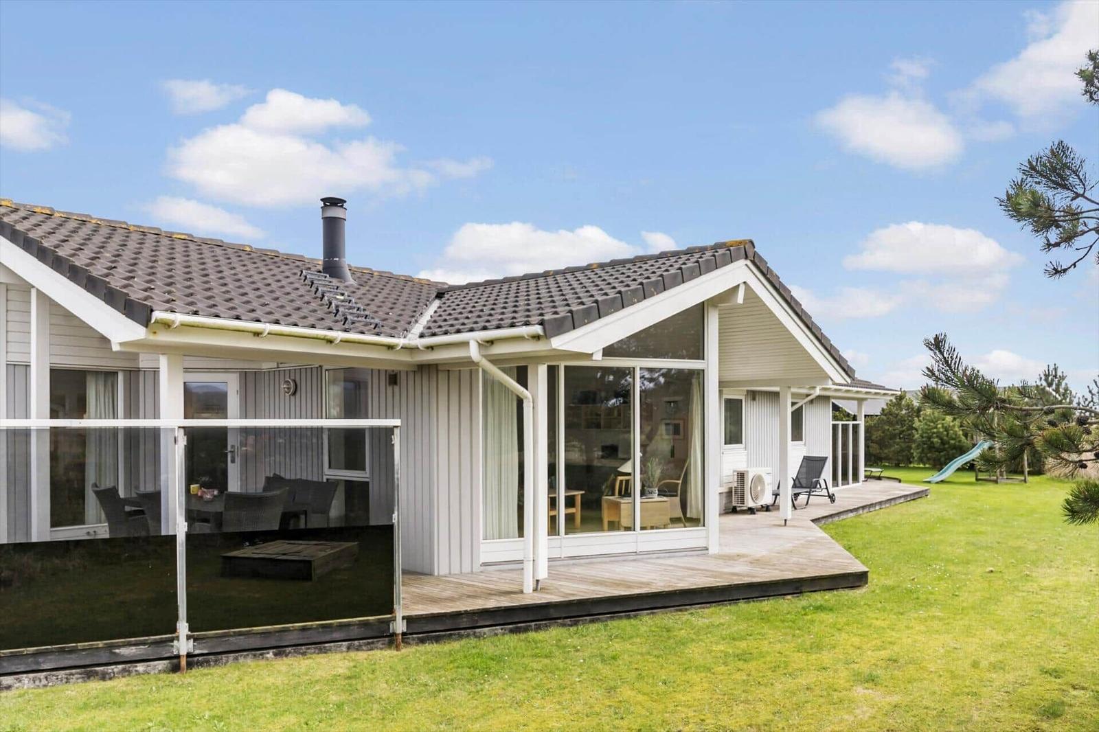 Moderne Ferienhaus mit Terrasse, Garten und Schlafzimmer. Außendusche und Holzterrasse.