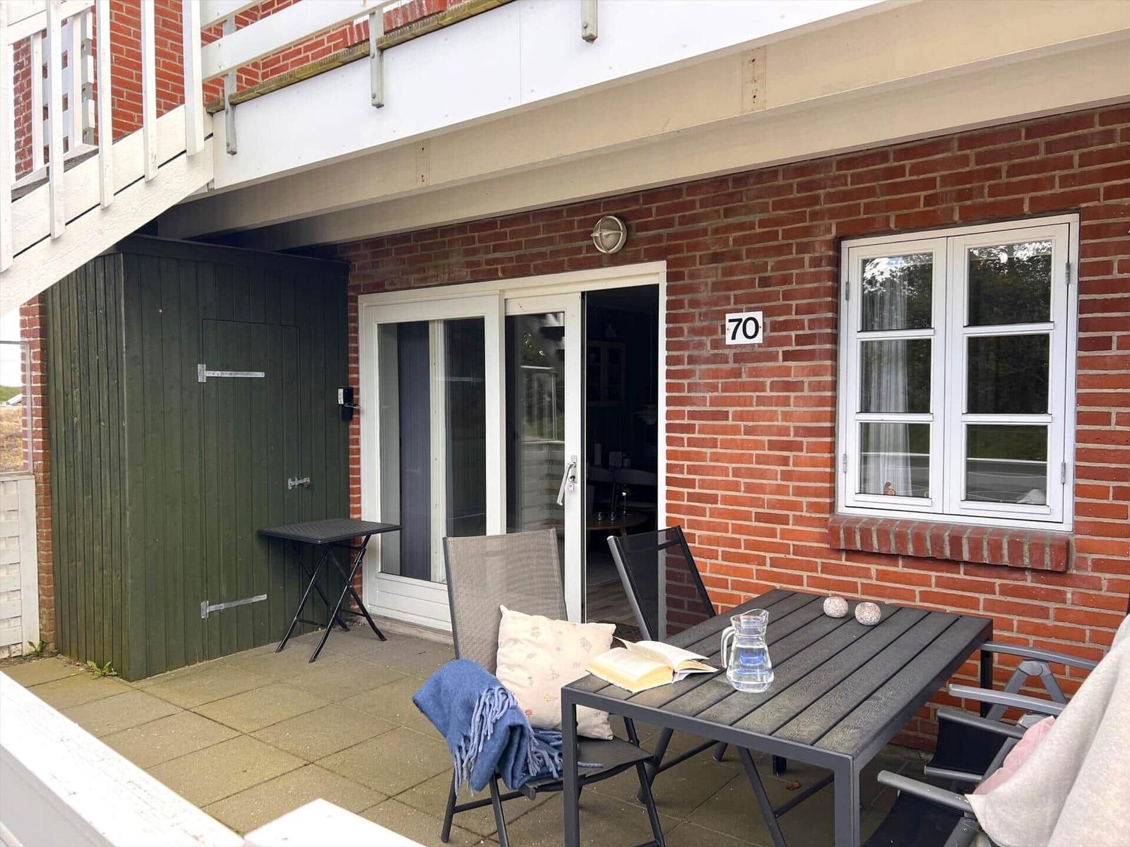 Terrasse mit Tisch, Stühlen und Blick in die Wohnung.