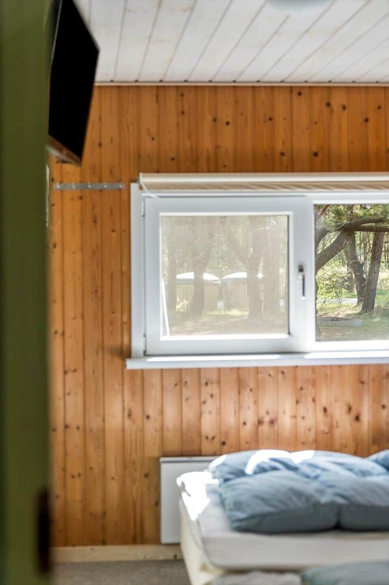 Schlafzimmer mit Holzwand, Fenster und Bett