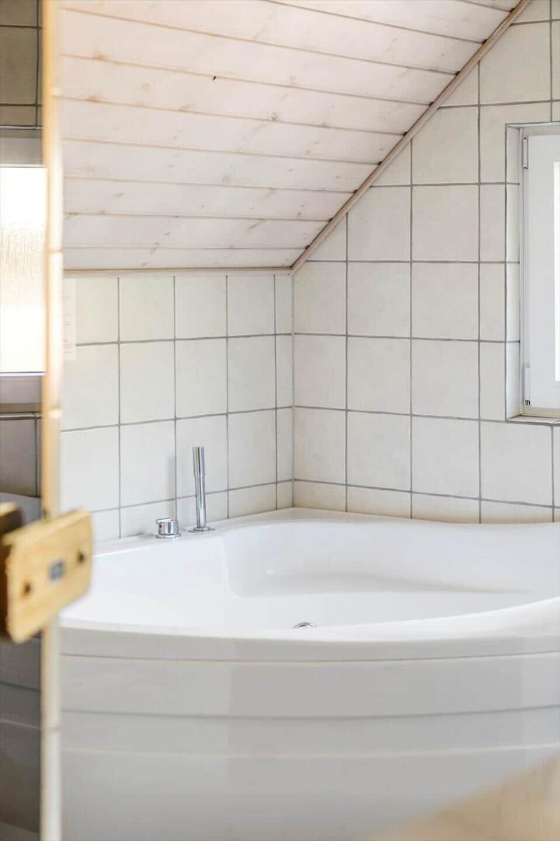 Dusche mit weißer Keramik und Holzdecke